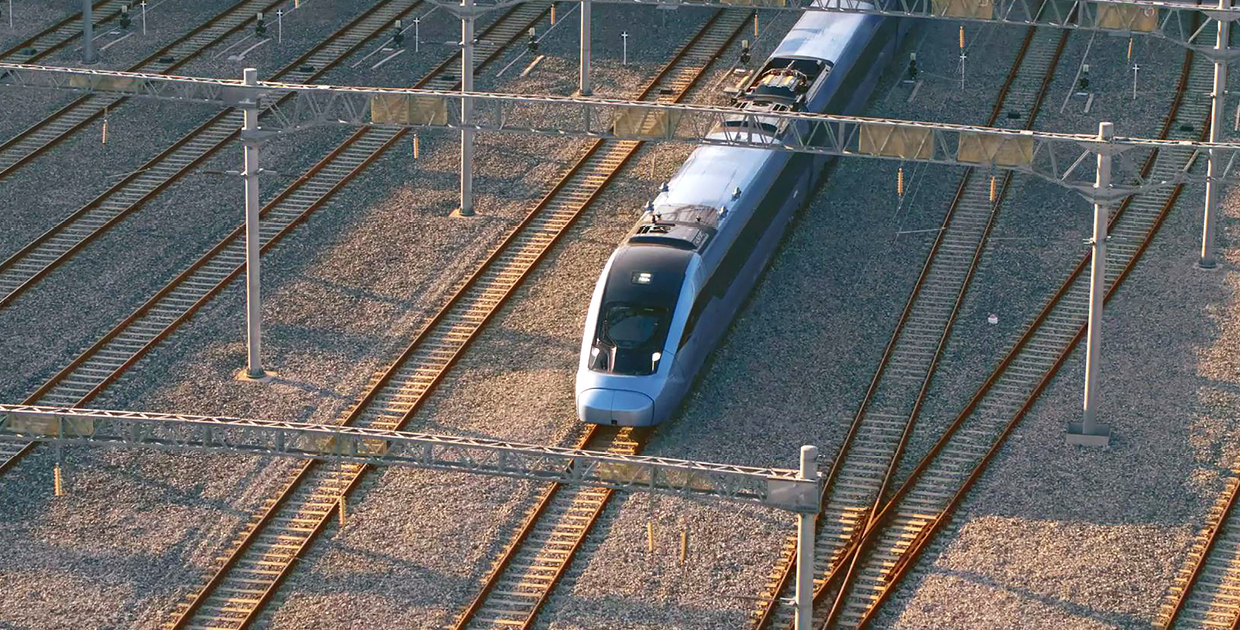 여러 개의 철길 중 가운데 선로로 파란색 기차가 달리는 사진