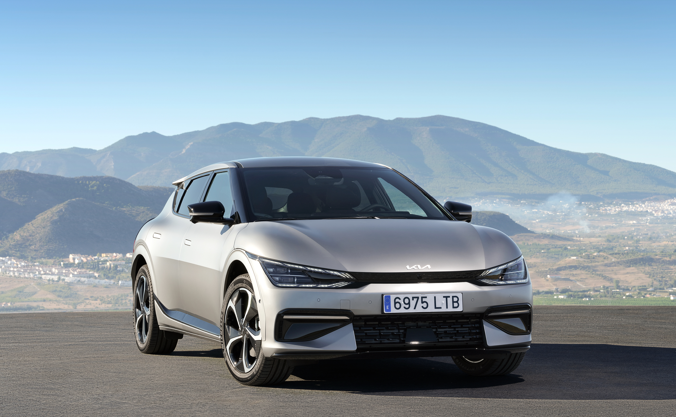 기아 EV6가 산속 도로를 질주하는 전측면 모습