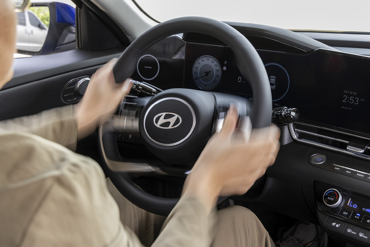 A man turning the steering wheel of an Avante