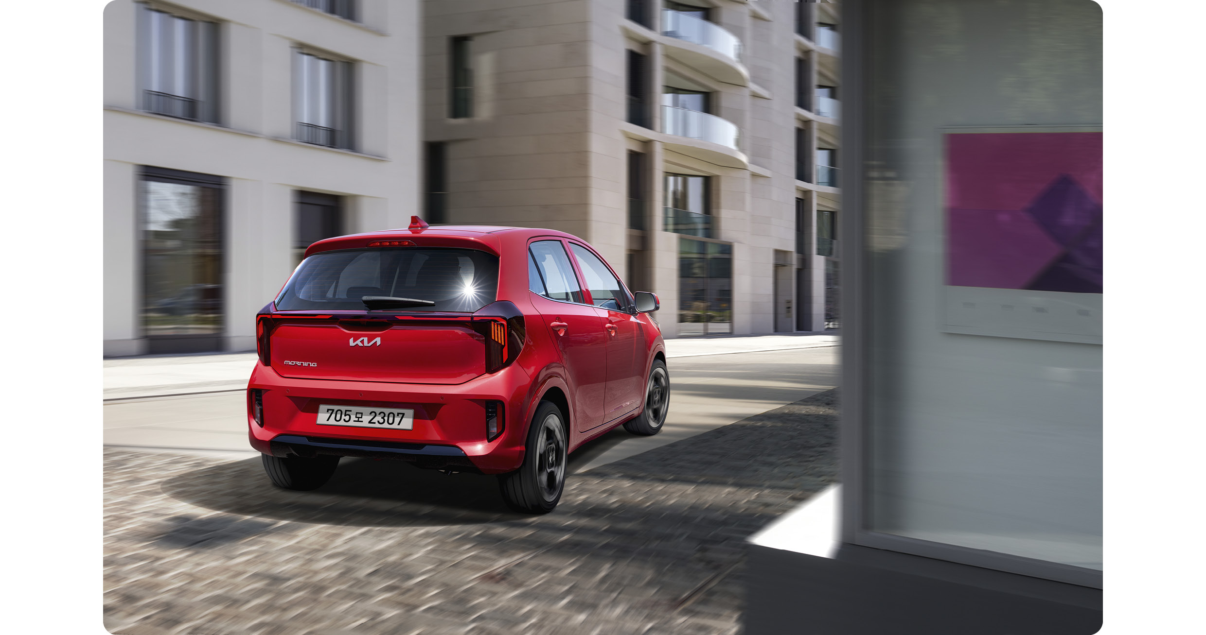 도심을 주행하는 모닝의 후측면 모습