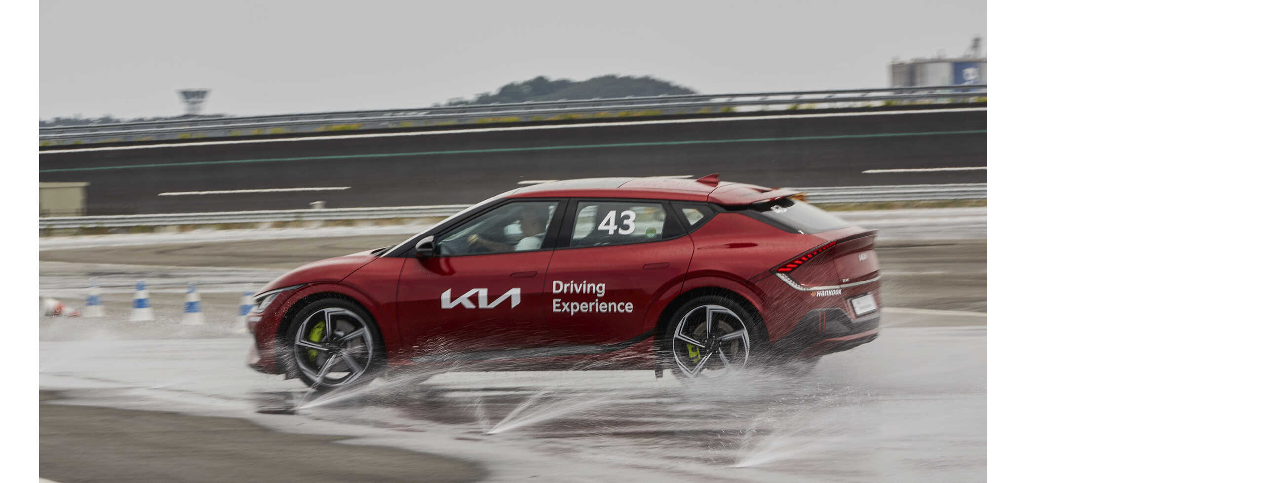 Rear/side view of an EV6 GT skidding on a wet road