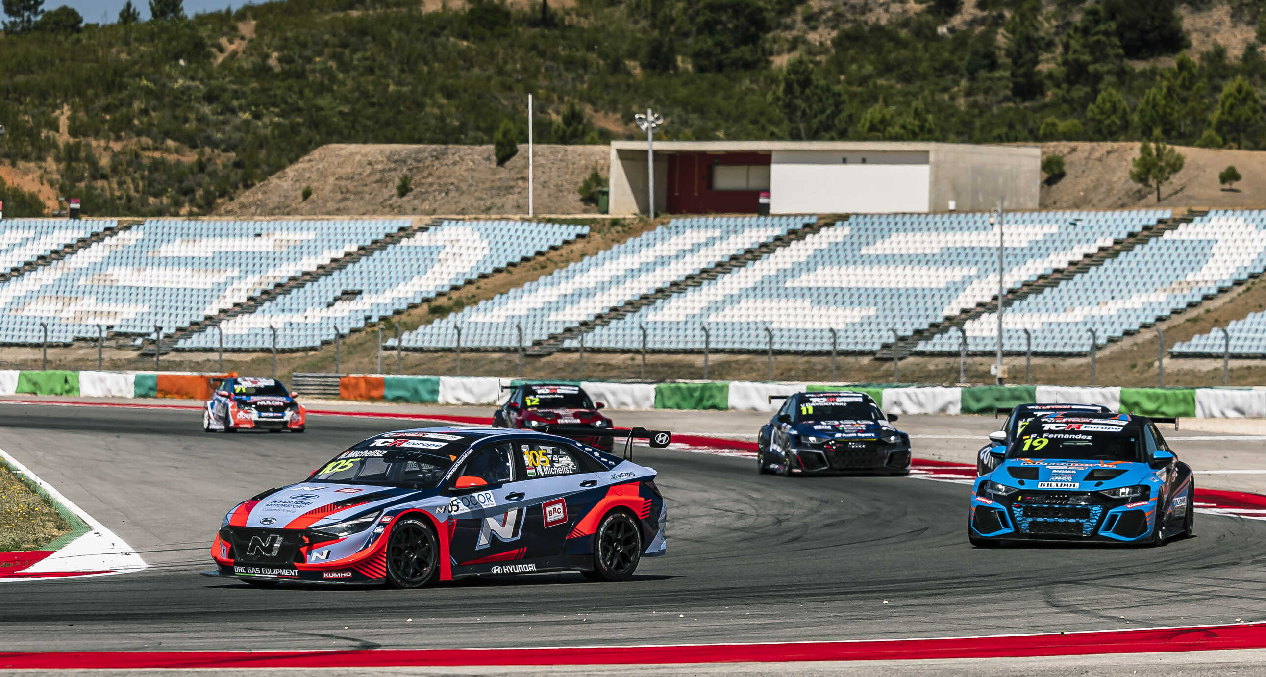 Rows of touring race cars running the circuit