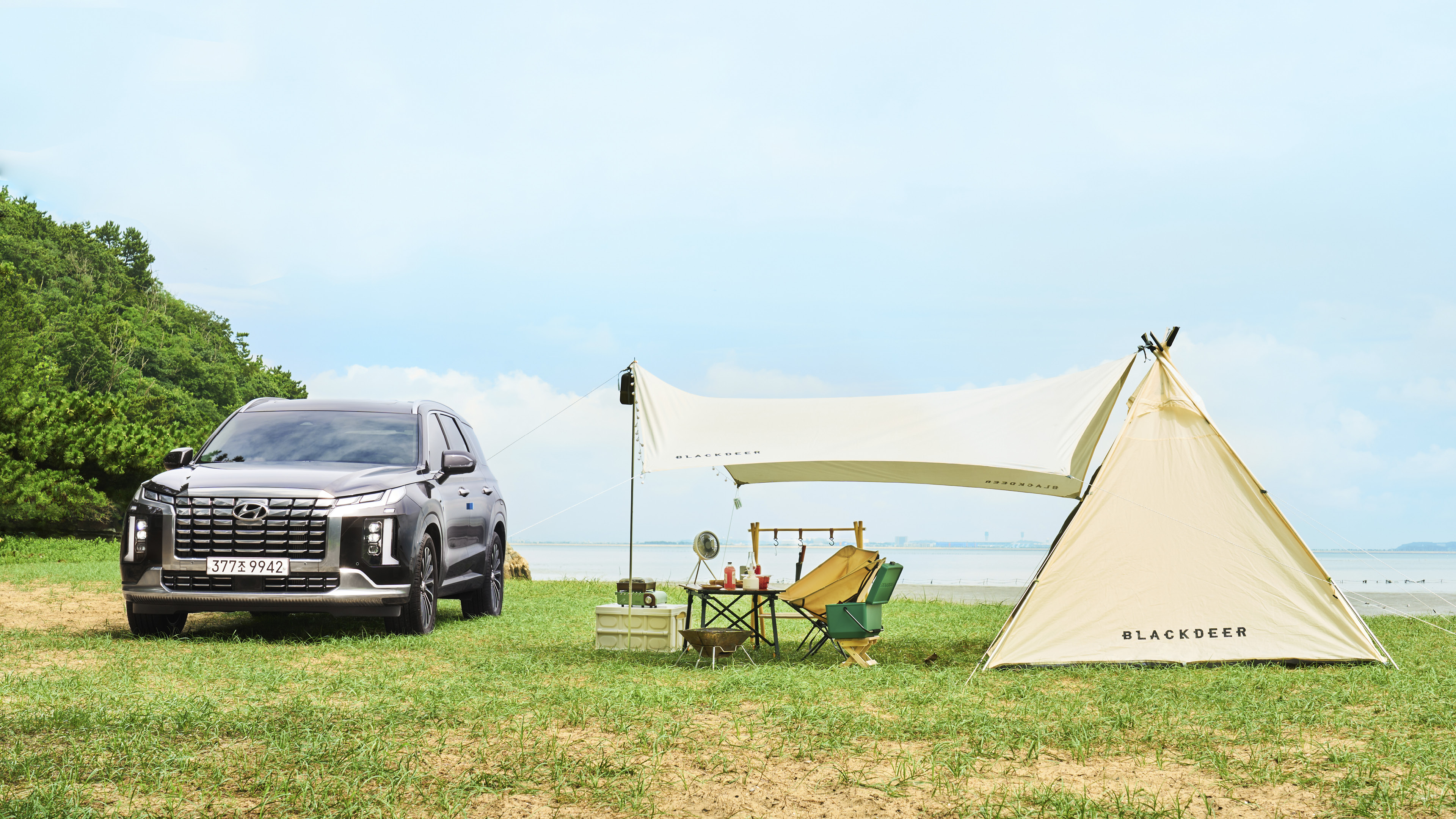 해변에 캠핑 용품과 함께 서 있는 팰리세이드