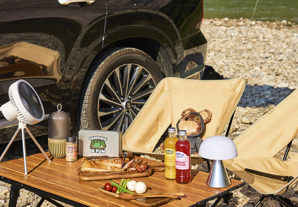 타프 아래 갖가지 캠핑 용품과 간단한 음식이 준비된 모습