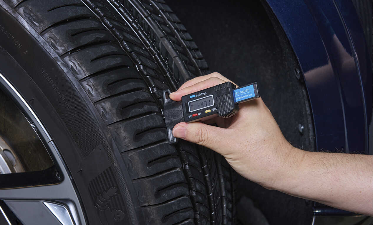 A man checking tire wear
