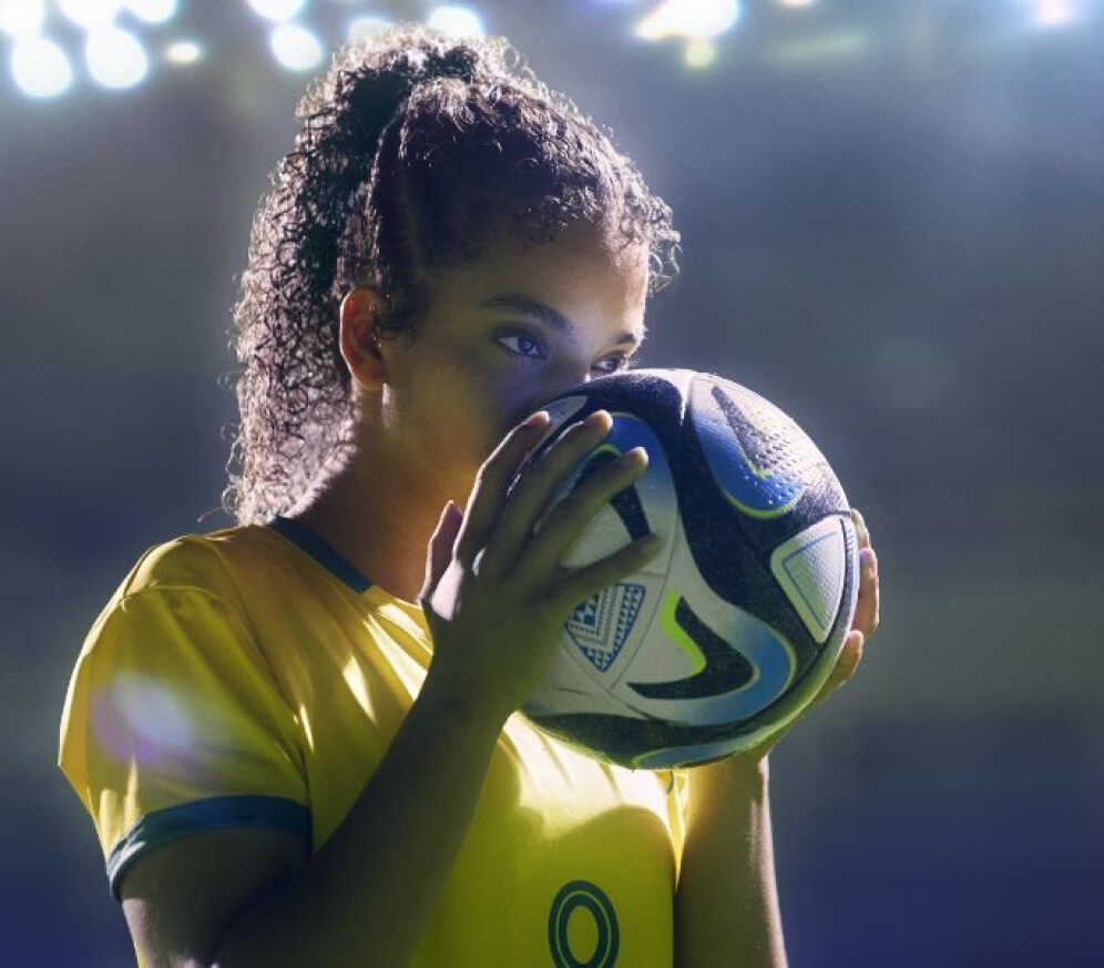 한 여성이 축구공을 두 손으로 잡고 있다