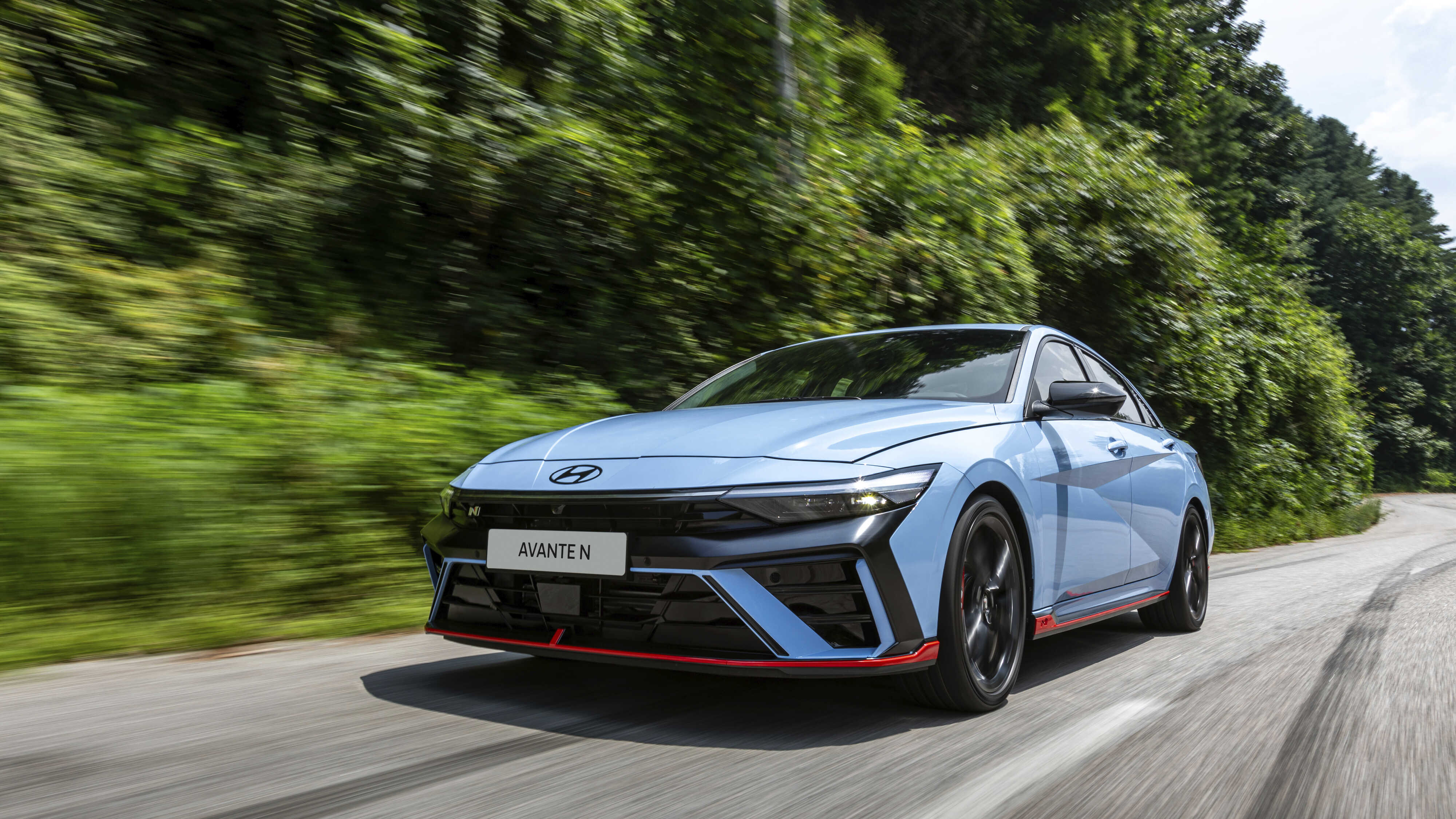 굽이진 도로를 달리고 있는 아반떼 N