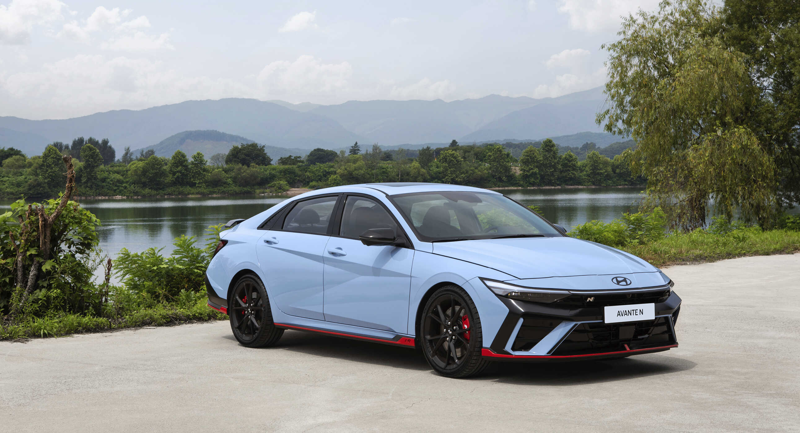 호수를 뒤에 두고 서 있는 아반떼 N