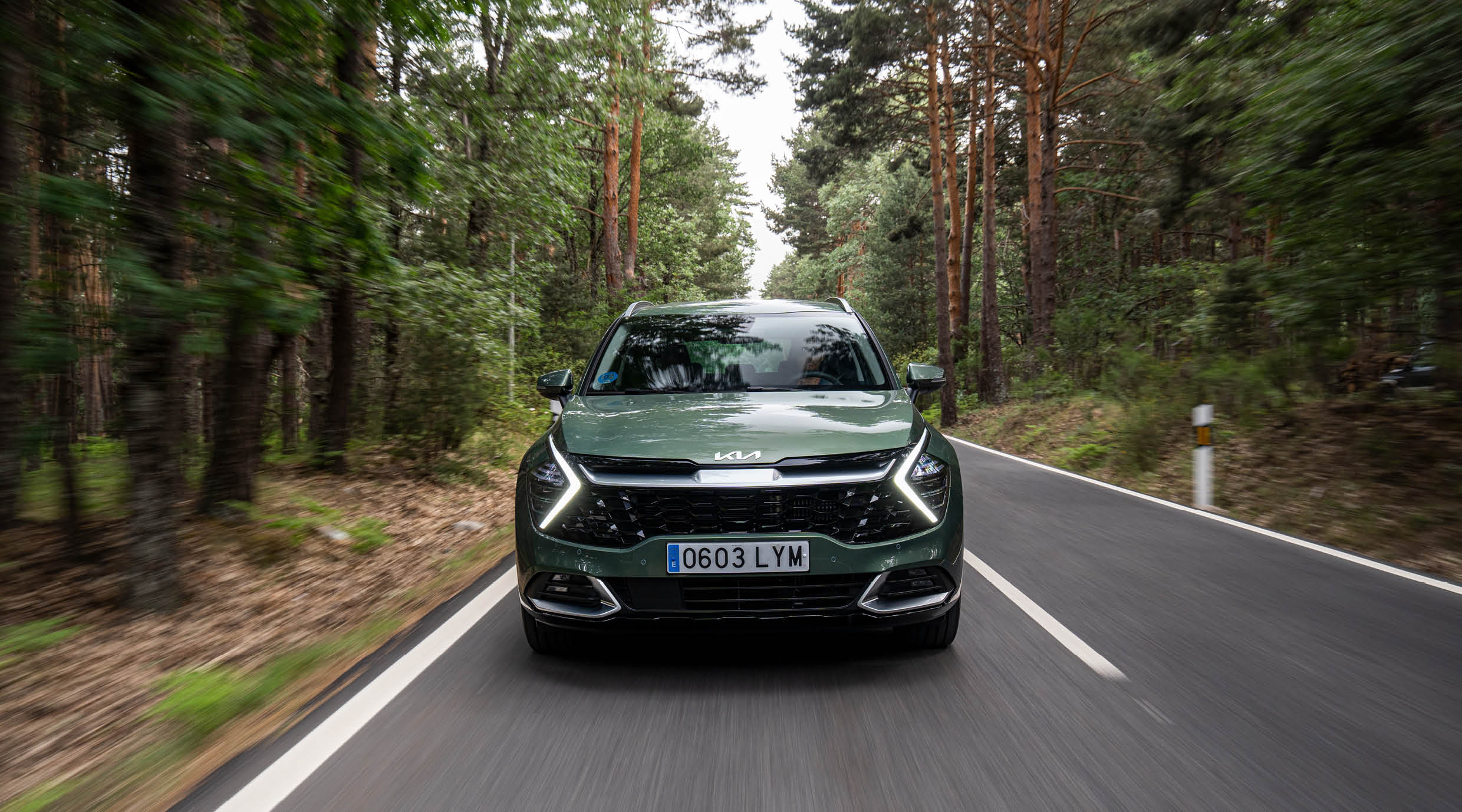 스포티지가 숲길을 주행하는 전면부의 모습