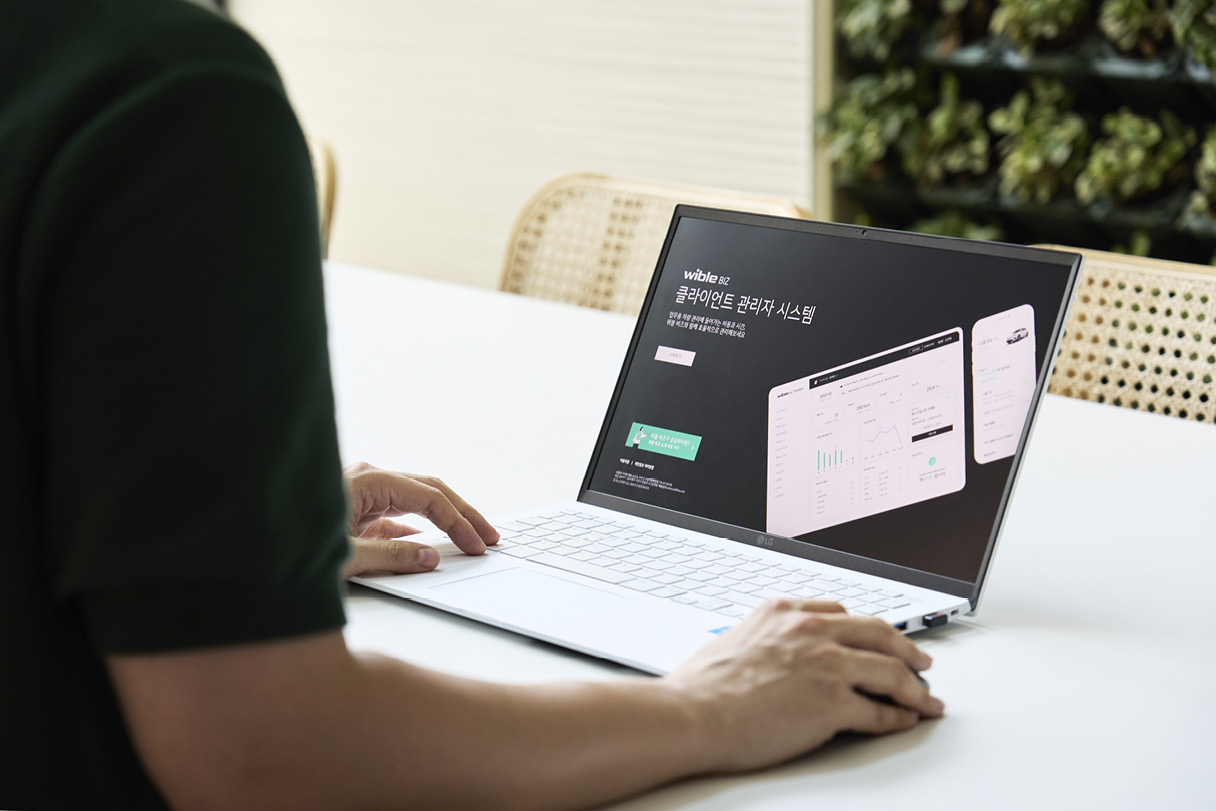 한 사람이 노트북 컴퓨터로 위블비즈 서비스를 이용하고 있다