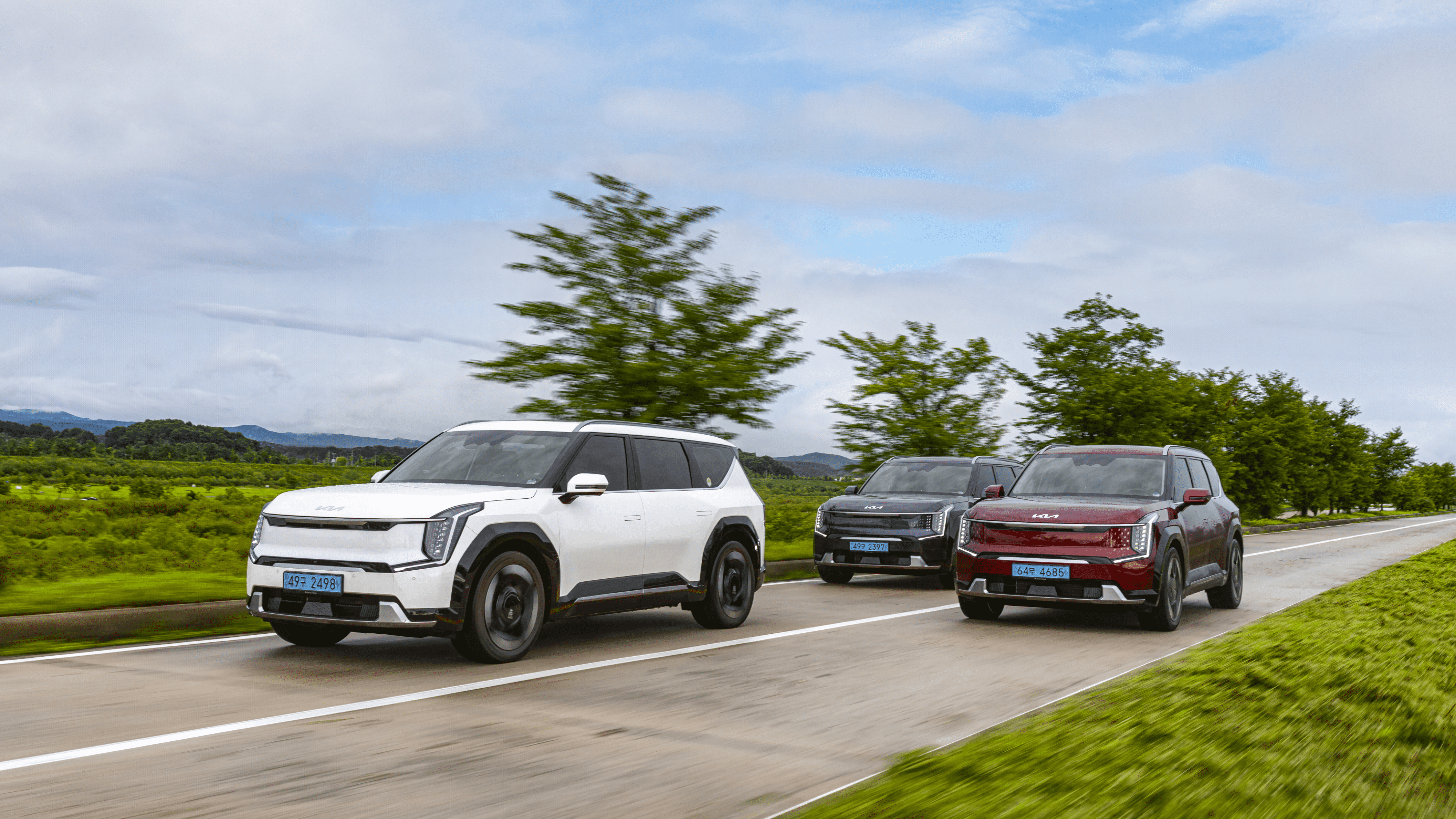 EV9 세 대가 주행하는 전측면 모습