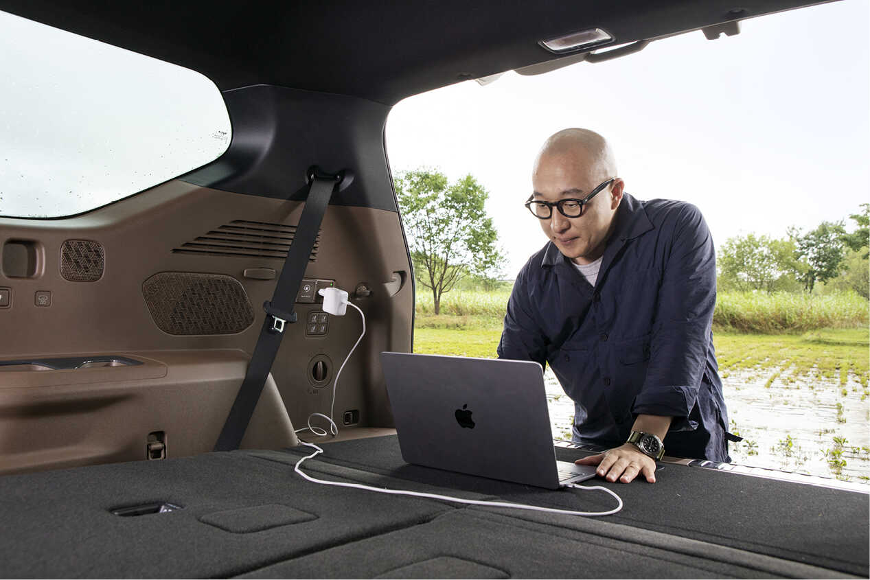 A man using a laptop in a 3rd-row passenger seat