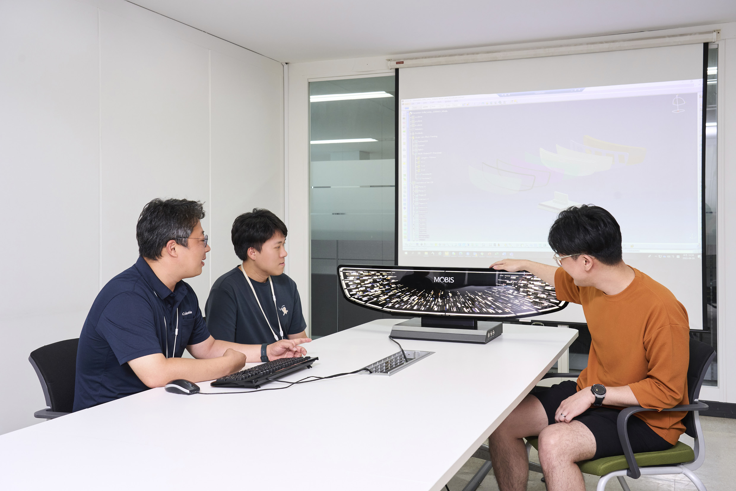 렌티큘러 그릴 라이팅 시스템을 개발한 연구원들에 대화를 나누는 모습