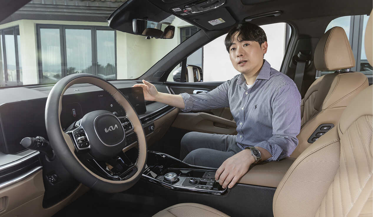 A man sitting in the passenger seat explaining while looking at the camera
