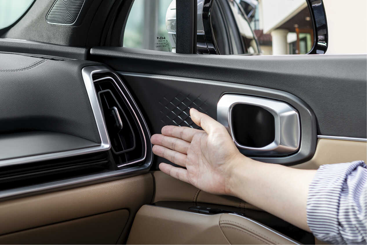 A man pointing to the passenger seat air vent