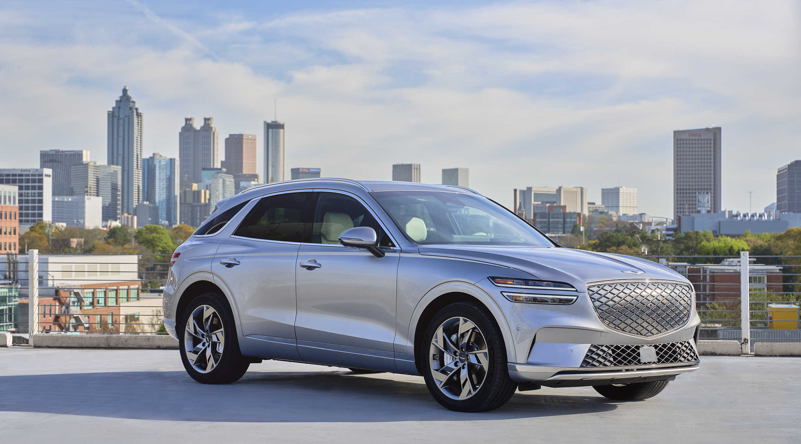 제네시스 GV70 전동화 모델이 미국 도시를 배경으로 주차한 전측면 모습