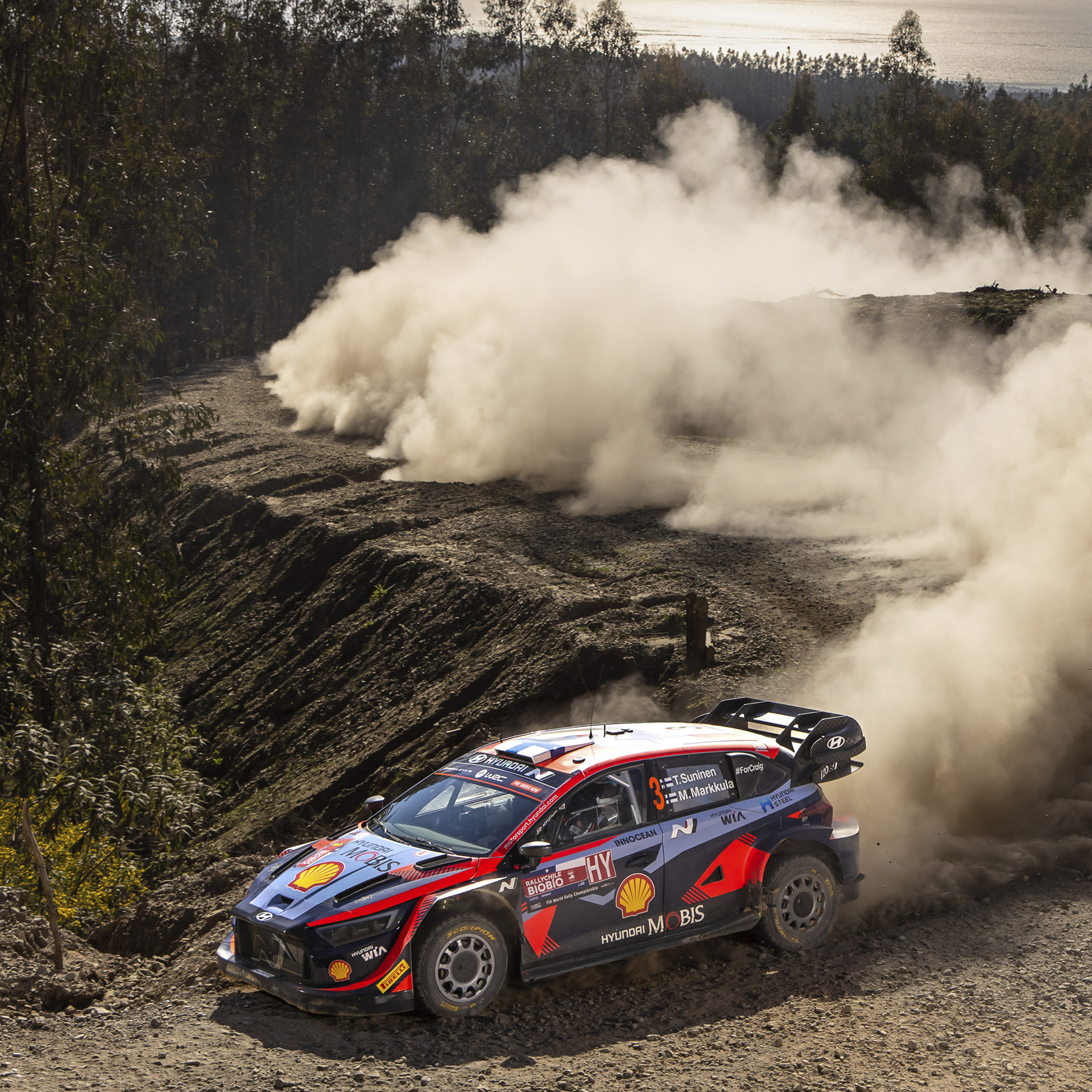 A Hyundai rally car is racing down a rough road