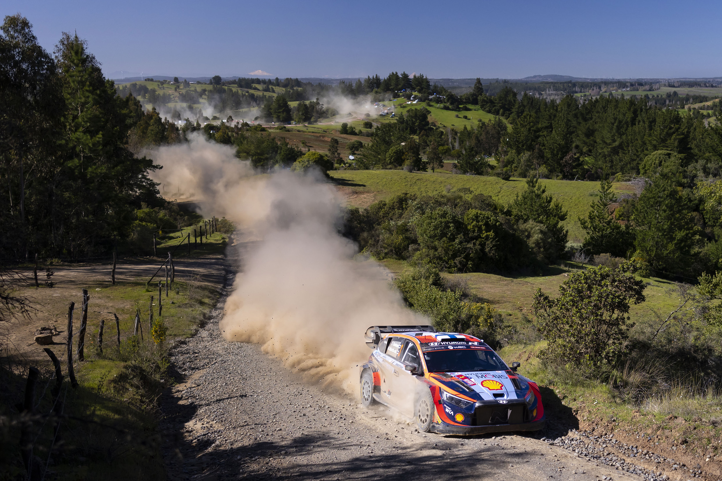 A Hyundai rally car is racing down a rough road.