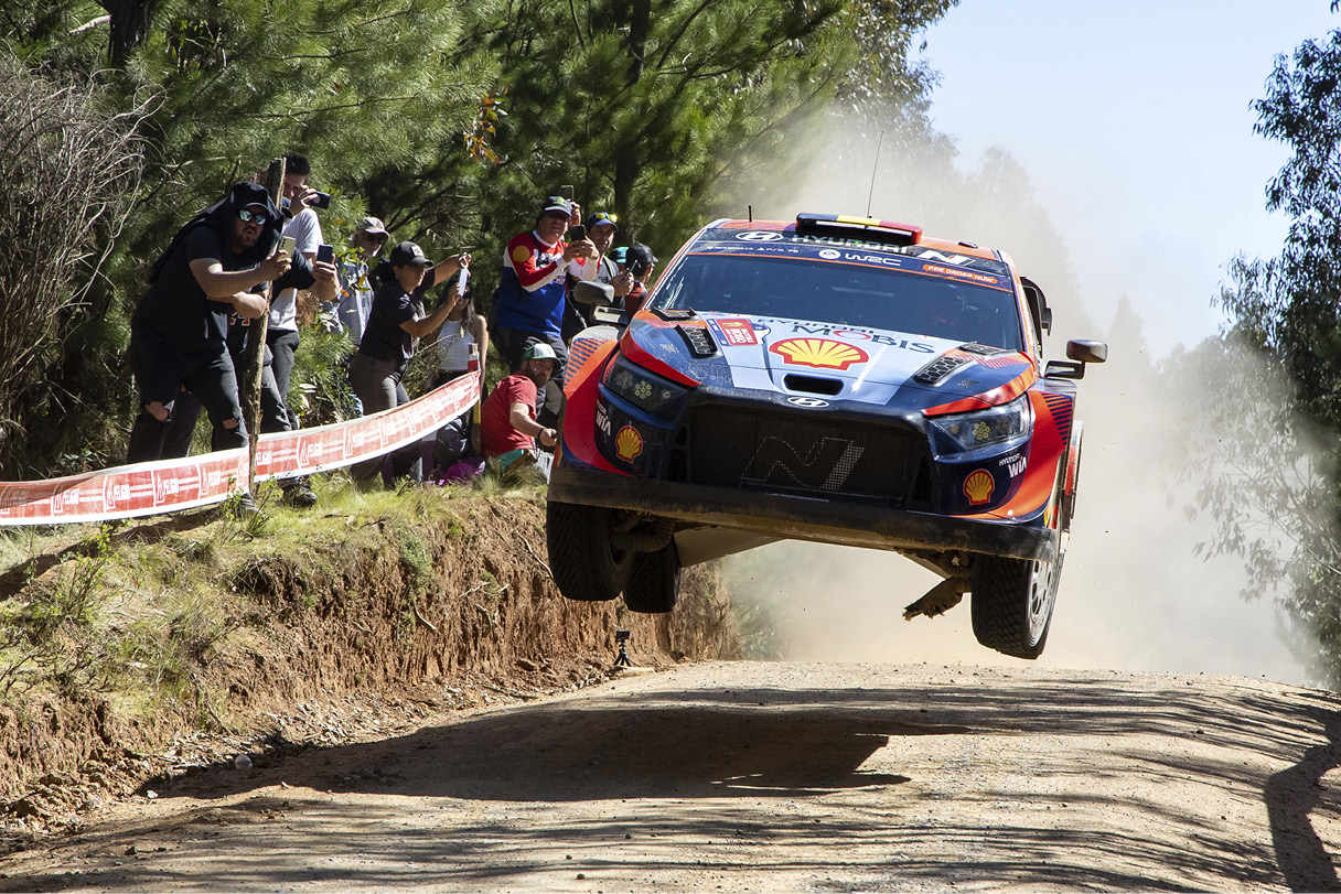 A Hyundai rally car is racing down a rough road.