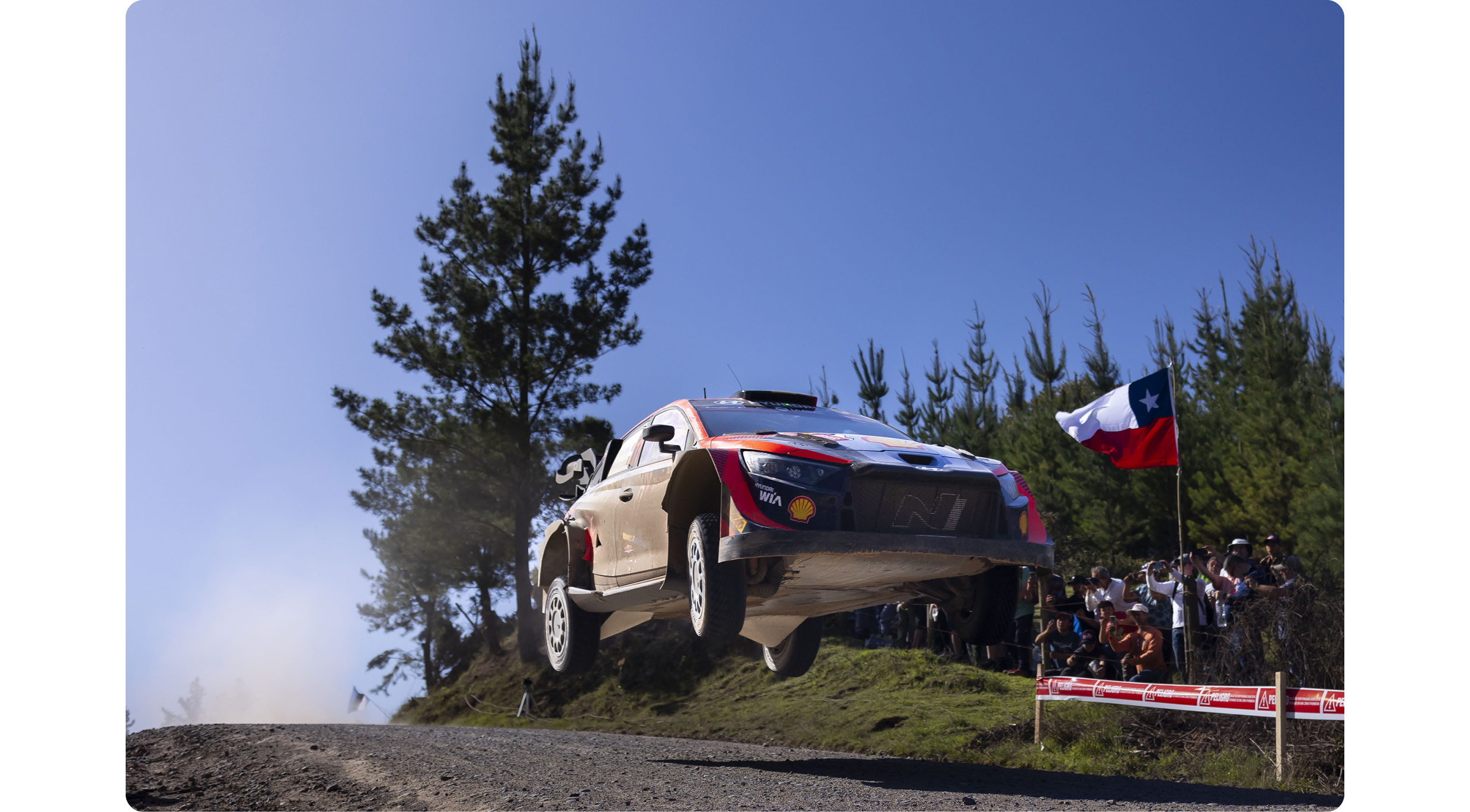 A Hyundai rally car is racing down a rough road.