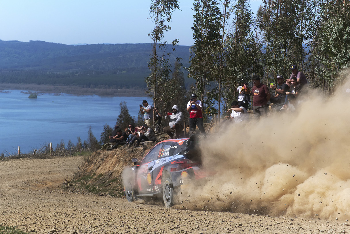 A Hyundai rally car is racing down a rough road.