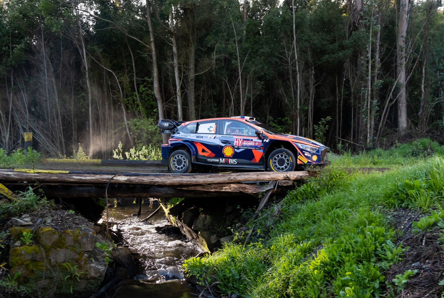 A Hyundai rally car is racing down a rough road