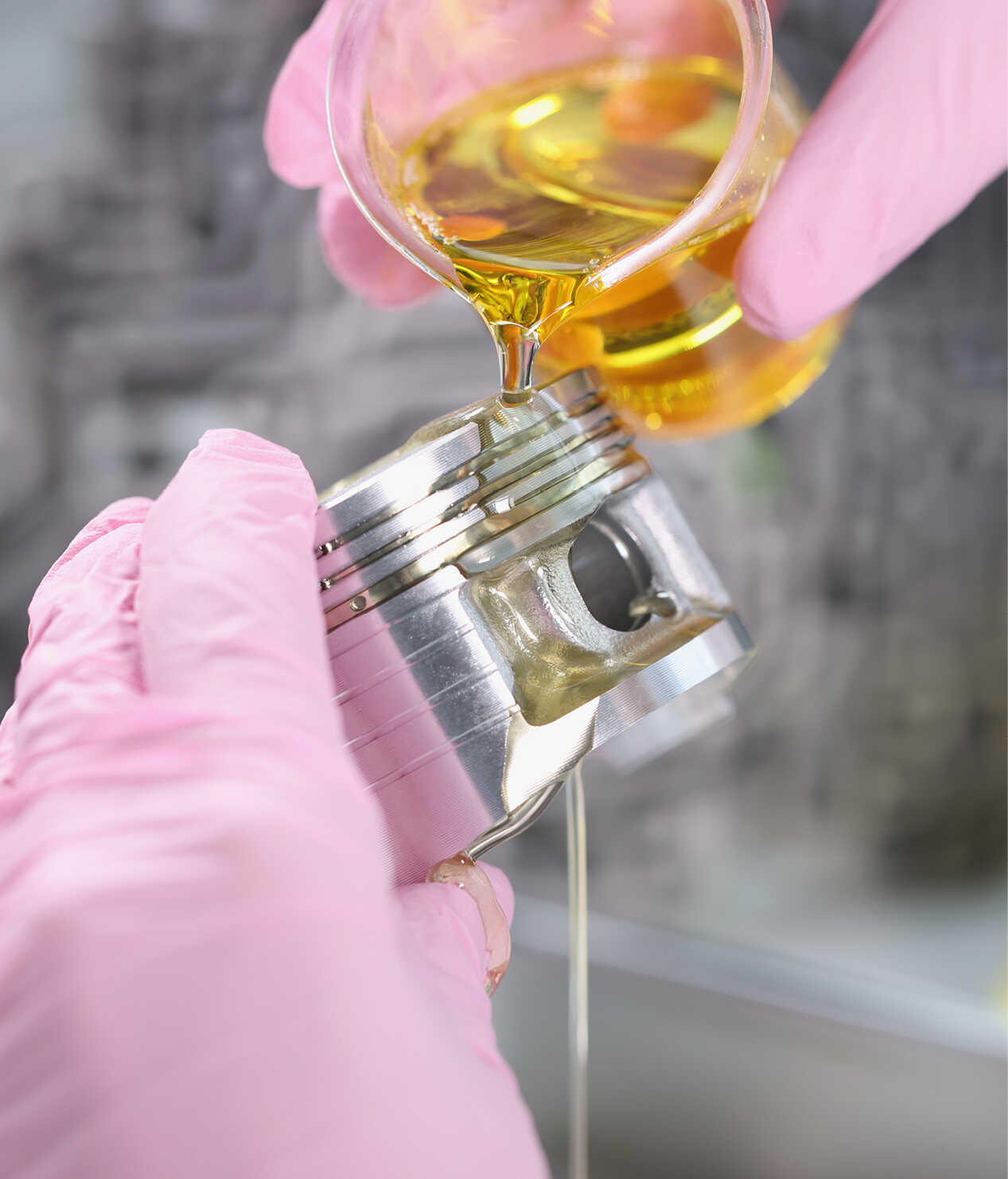 비커에 든 엔진오일을 피스톤에 묻히는 모습