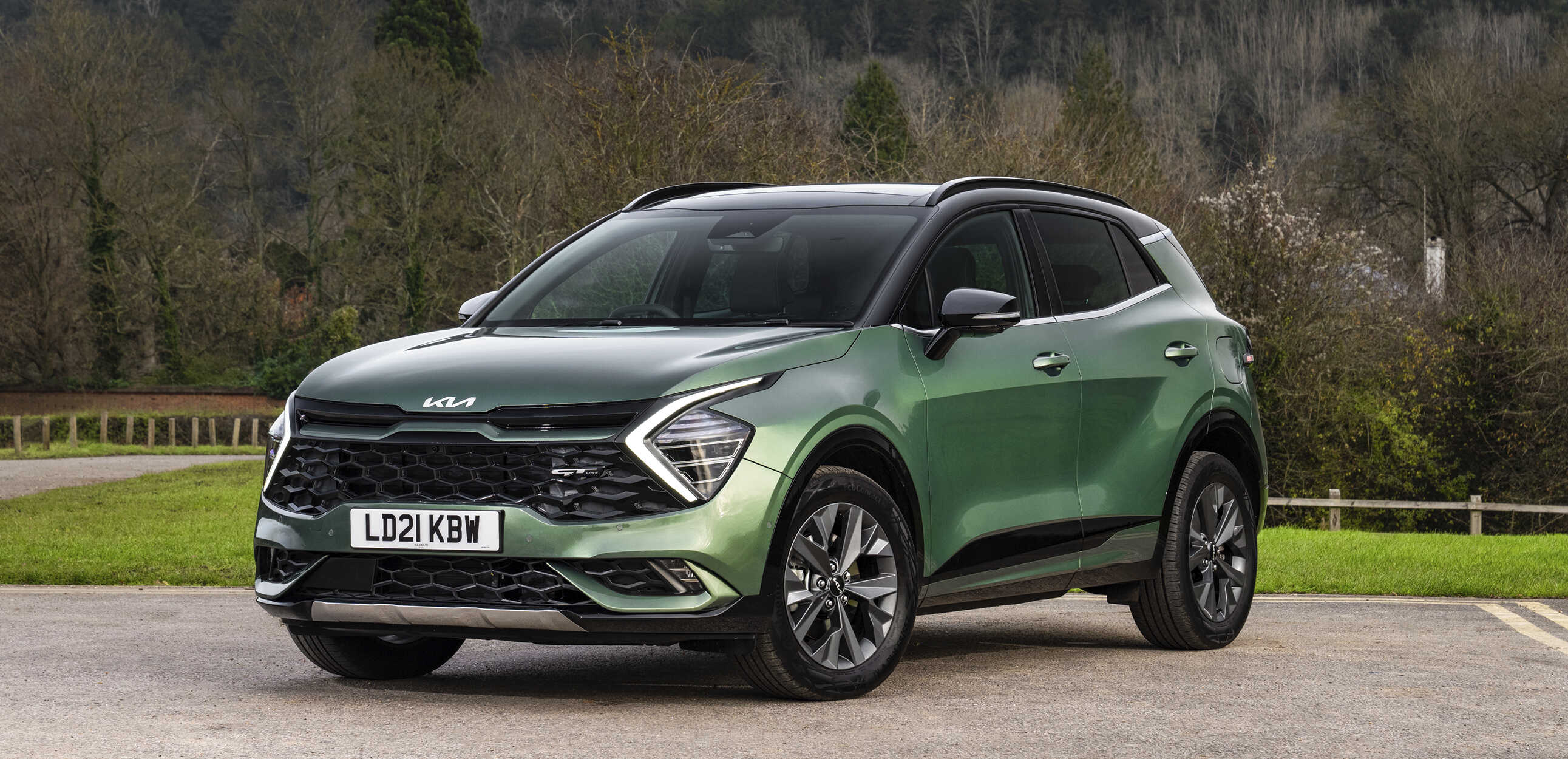 기아 스포티지가 숲을 배경으로 주차된 모습