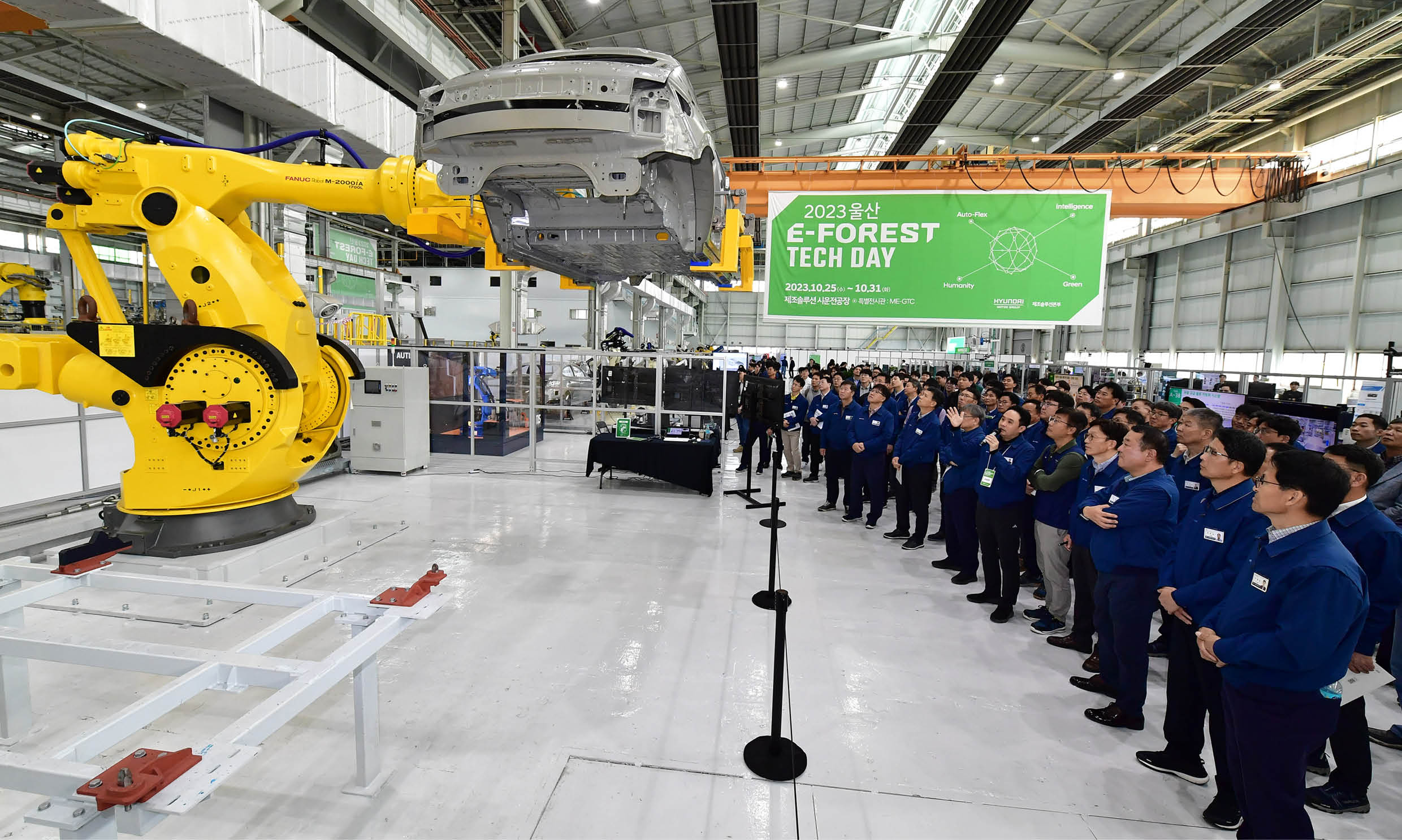 로봇팔이 움직이는 모습을 지켜보는 관계자들