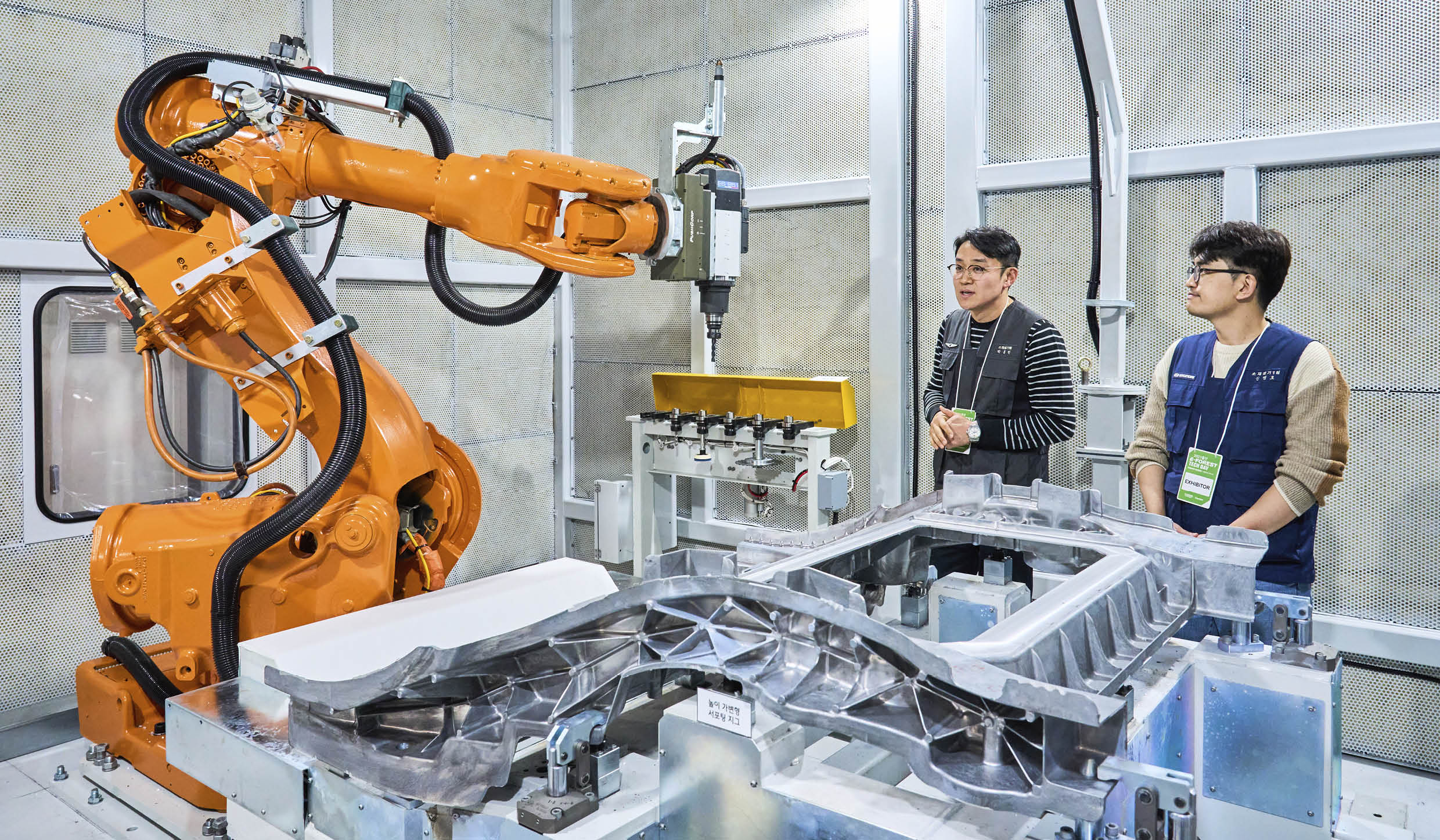 로봇팔이 작동하는 모습을 살펴보는 관계자들