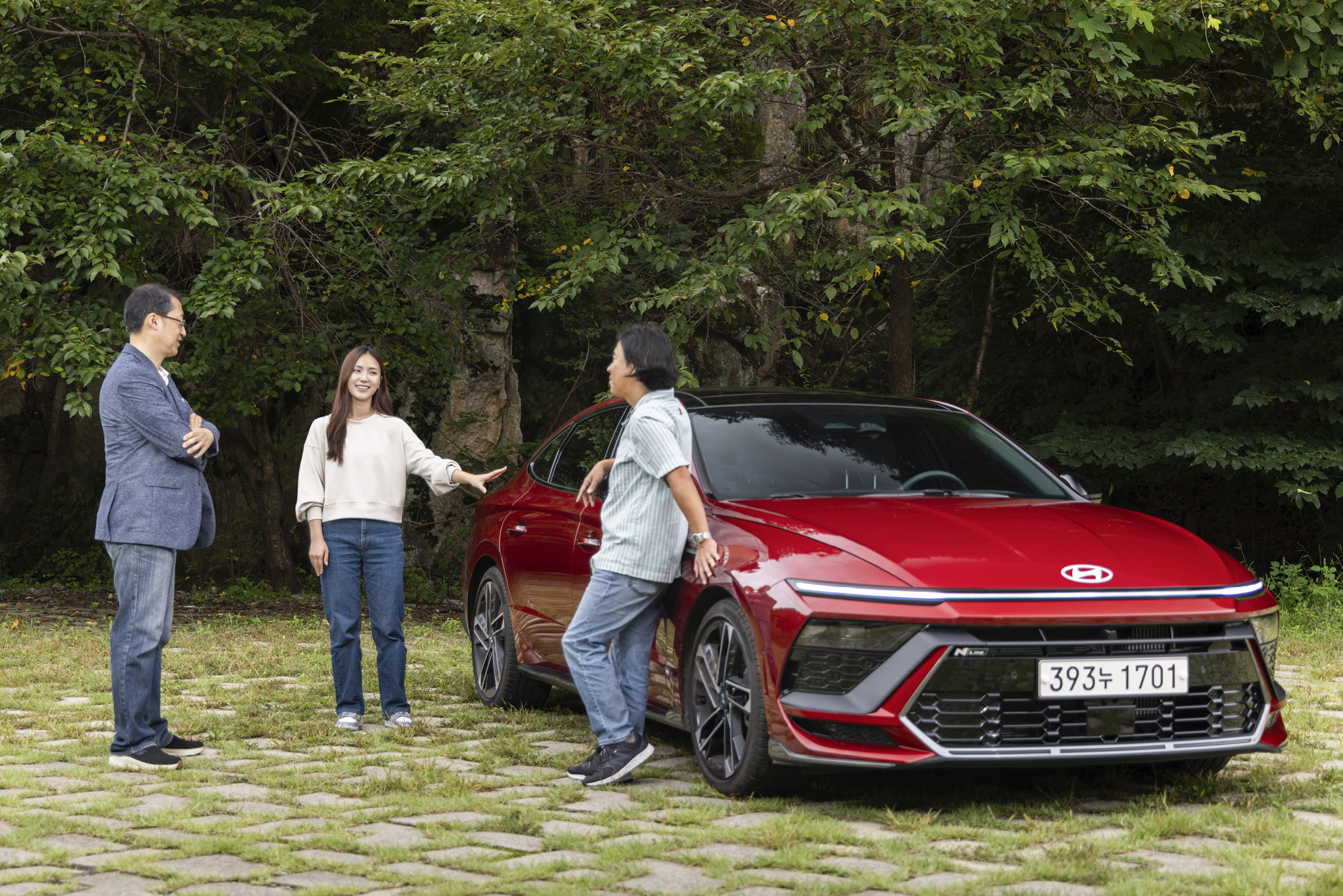 쏘나타 주변으로 성인 세 명이 서 있는 모습