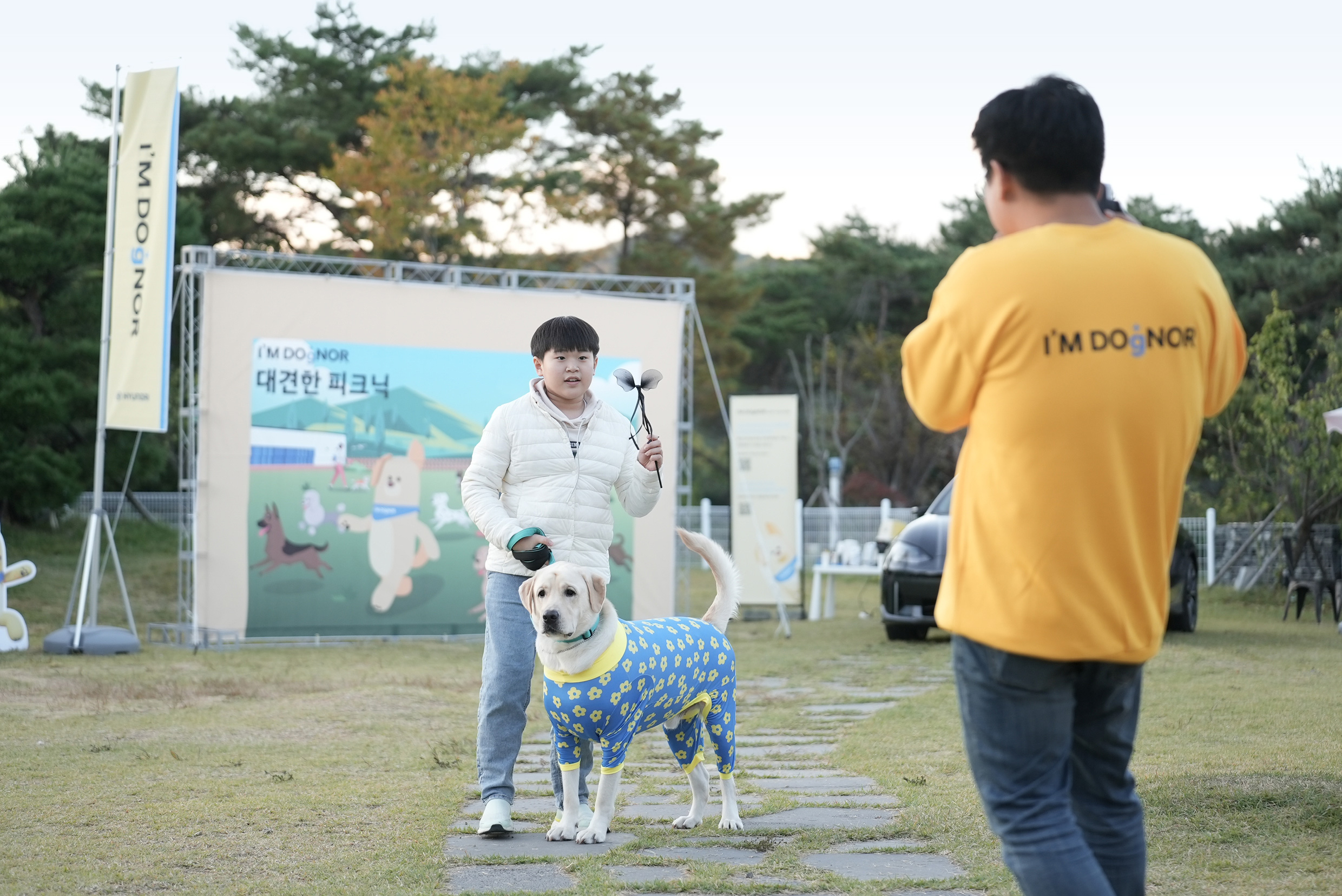 Dog owners and large dogs taking photos at the I’M DOgNOR event