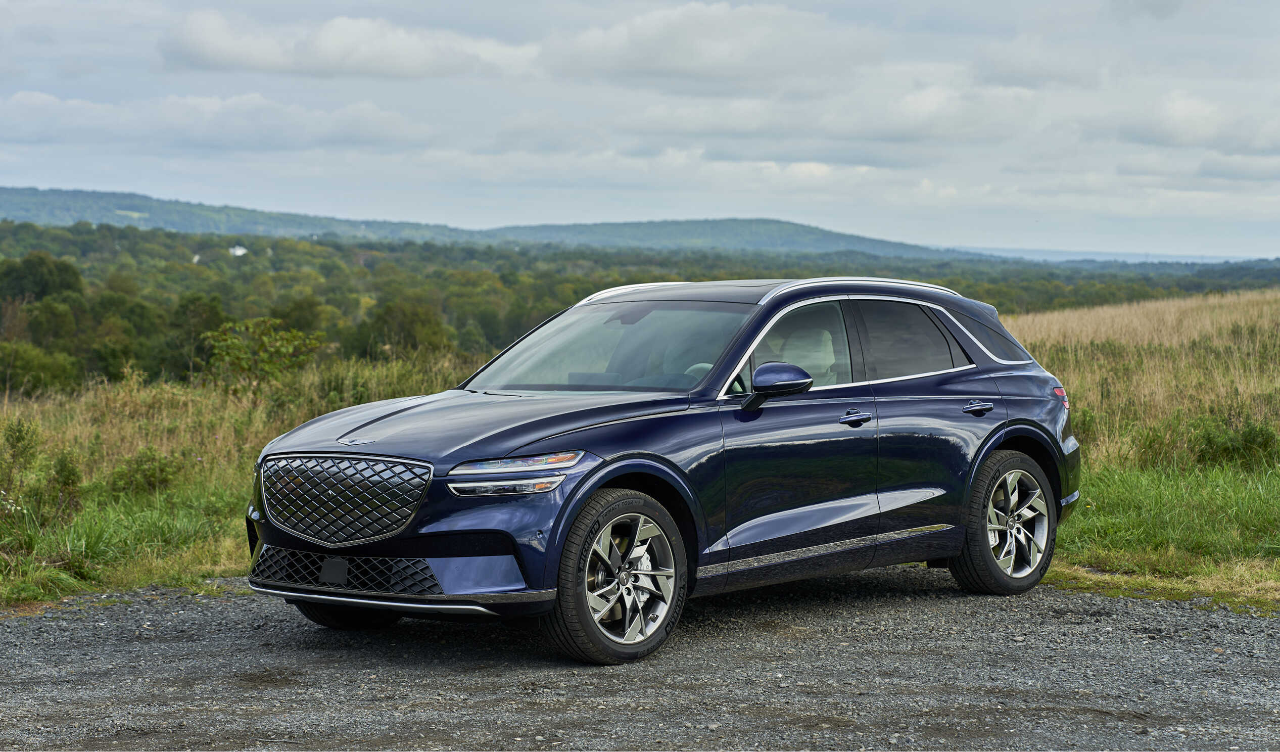 제네시스 GV70 전동화 모델이 한적한 들판에 주차한 전측면 모습