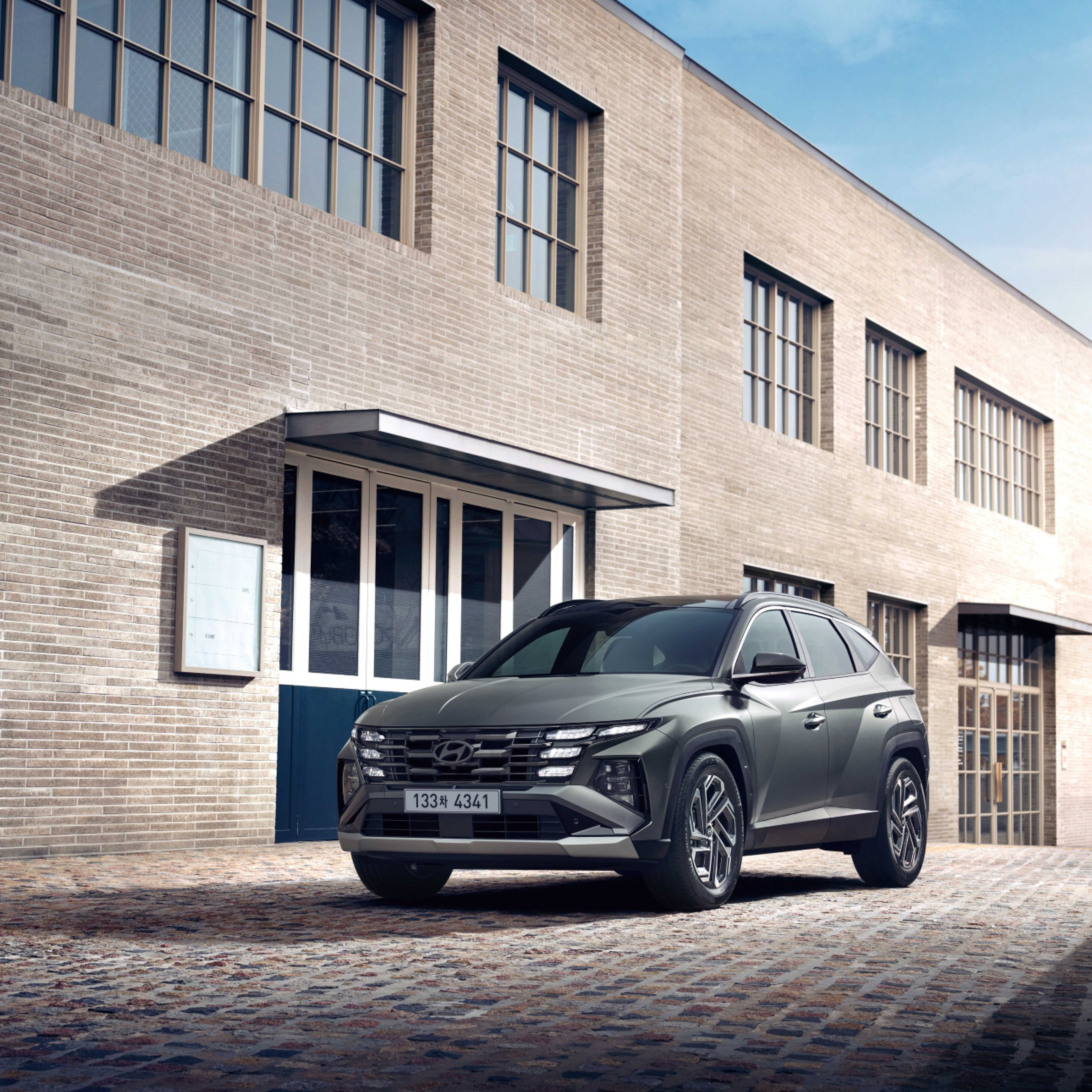 모던한 건물 앞에 서 있는 더 뉴 투싼