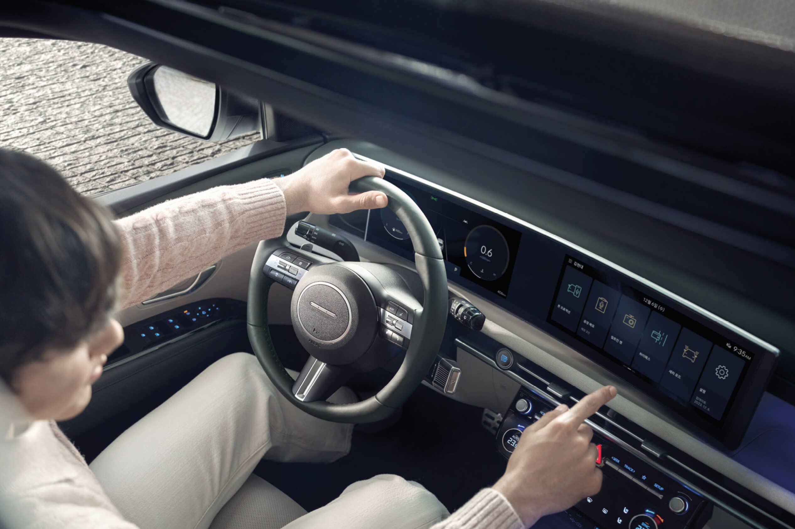 A driver operating the display screen from the driver's seat of The New Tucson
