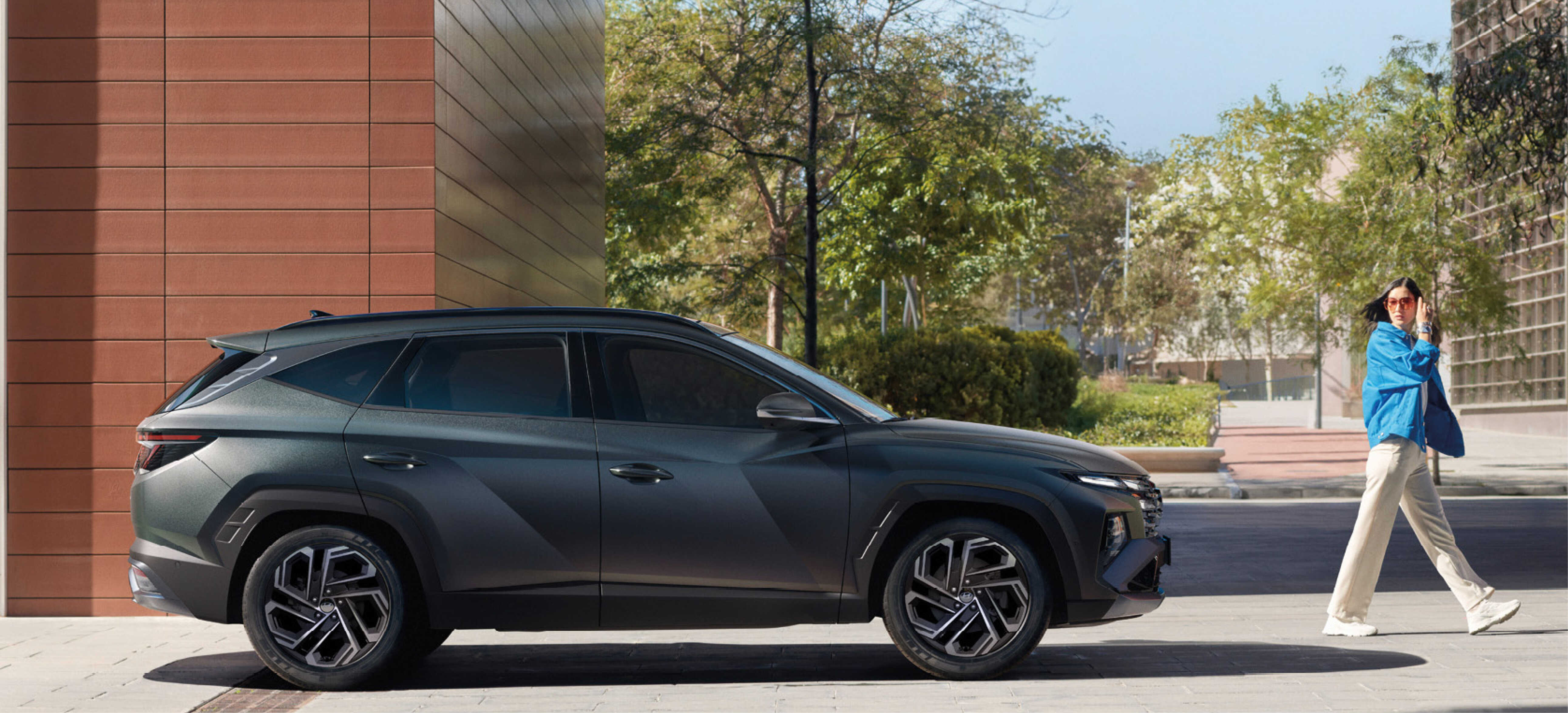 더 뉴 투싼을 바라보며 걷고 있는 사람의 모습