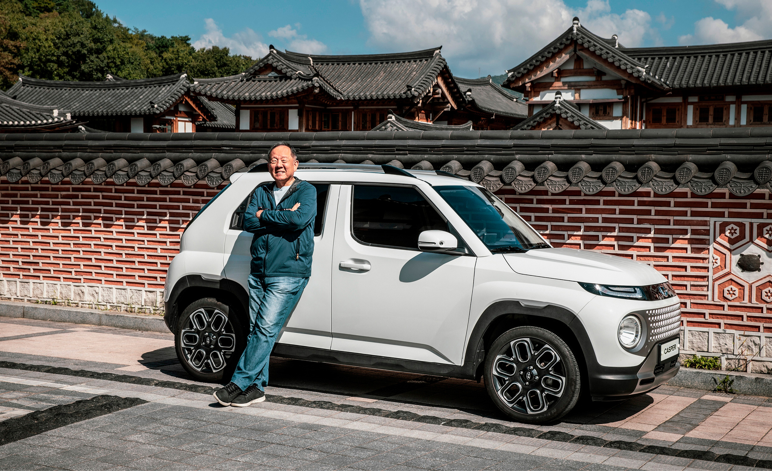 한옥 돌담에 서 있는 캐스퍼에 기대고 팔짱을 낀 박규철 칼럼니스트