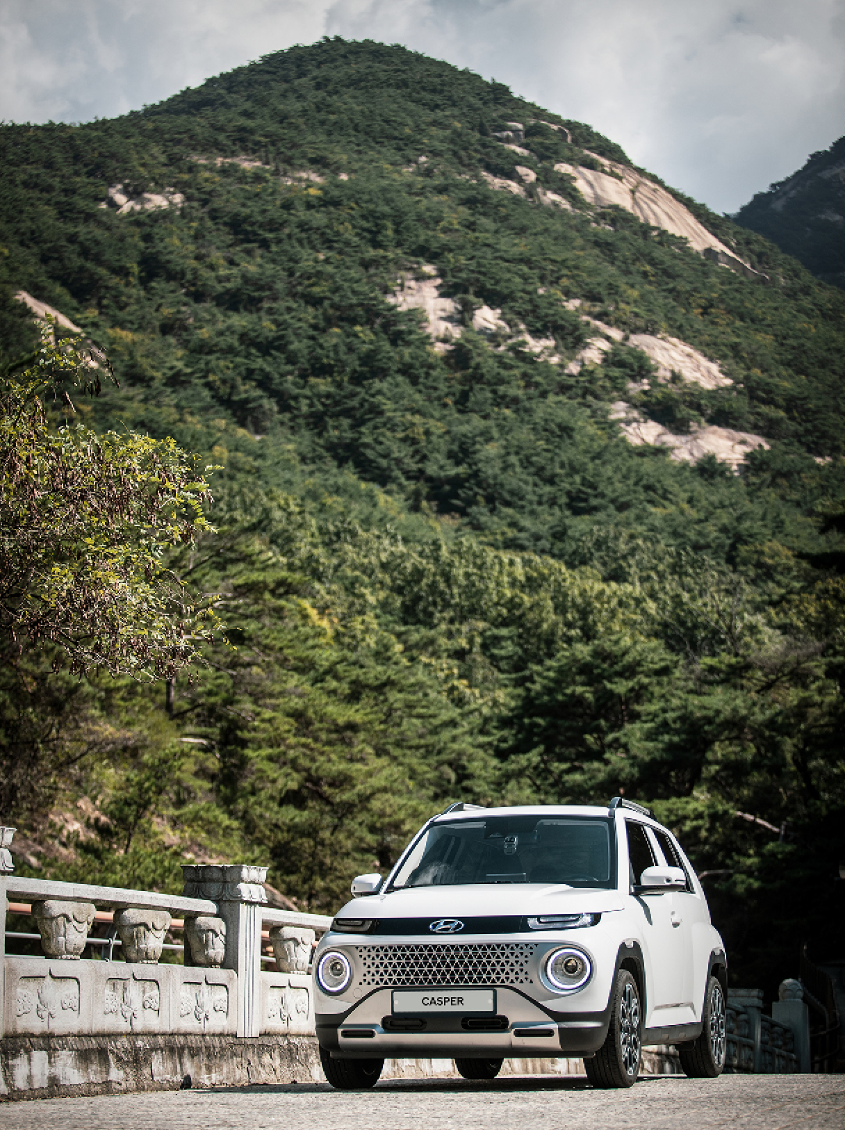 산 속 돌다리에 서 있는 캐스퍼 앞모습