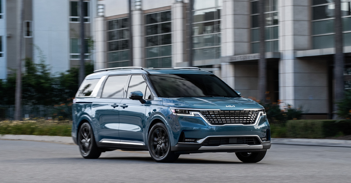 기아 카니발이 도심 도로를 주행하는 전측면 모습