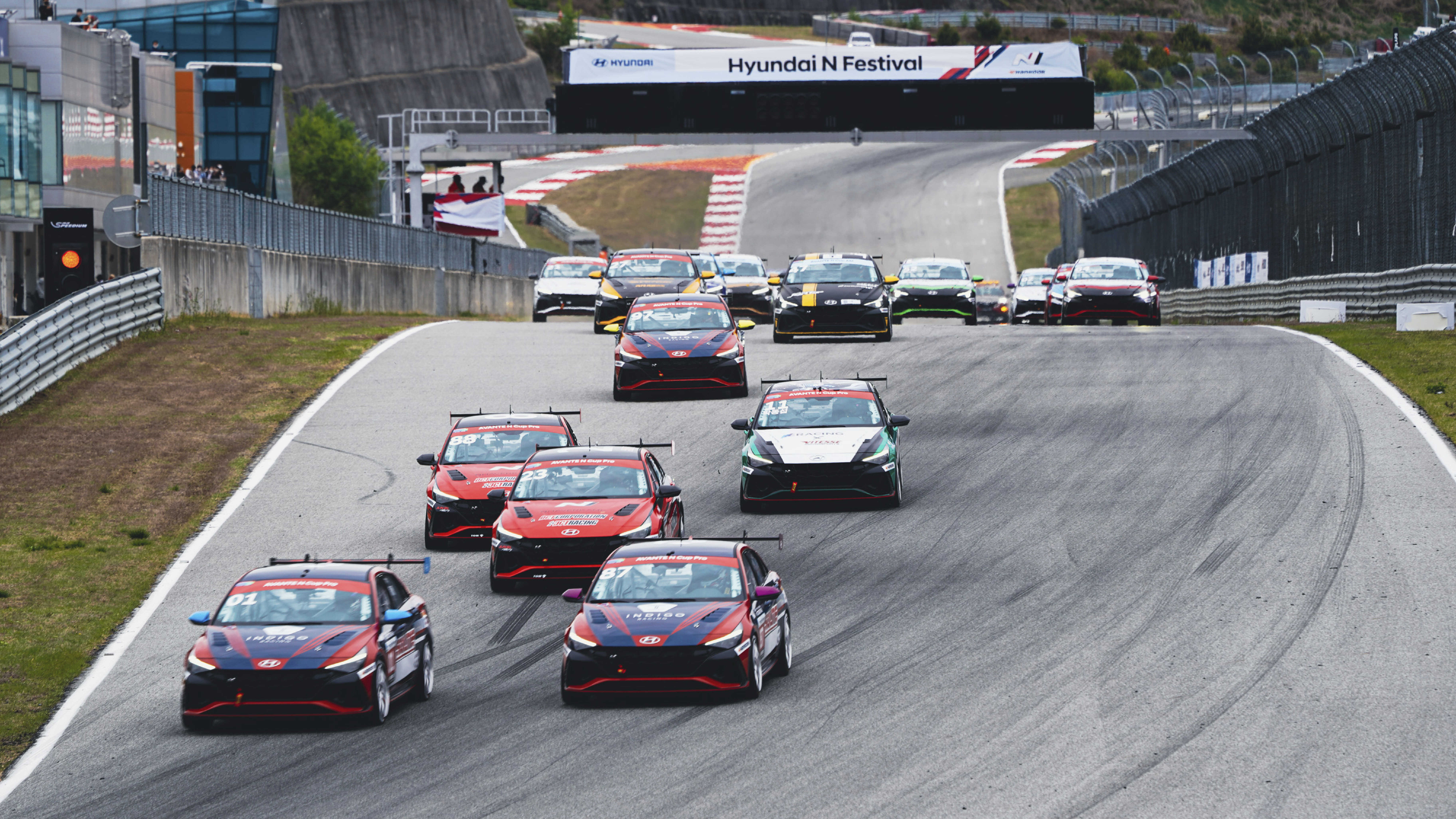 Multiple race cars racing around a circuit