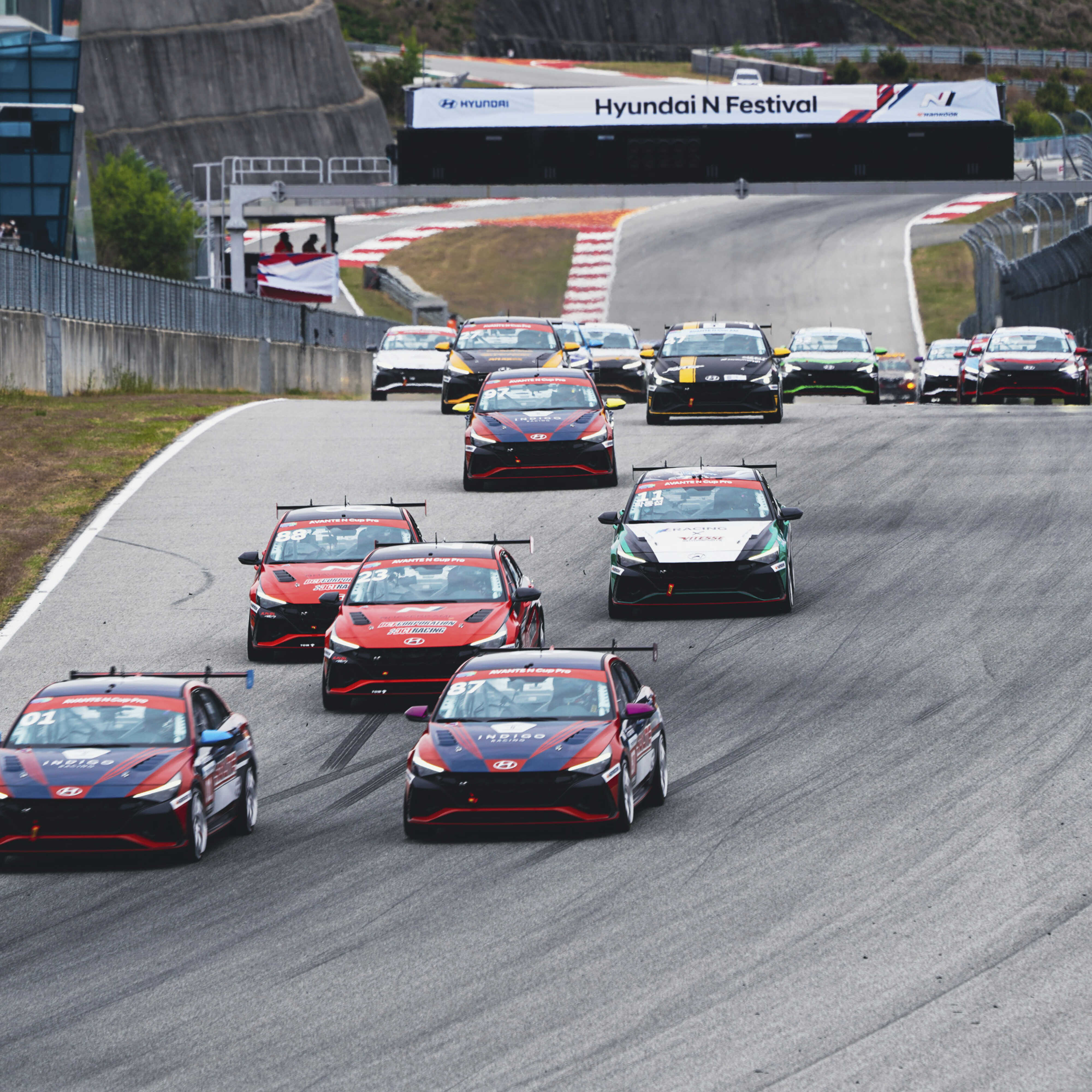 Multiple race cars racing around a circuit