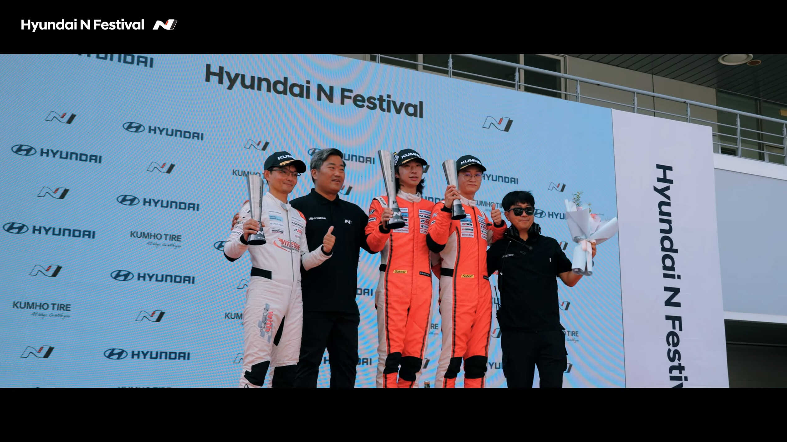 포디엄에서 기념사진을 찍는 레이서들의 모습