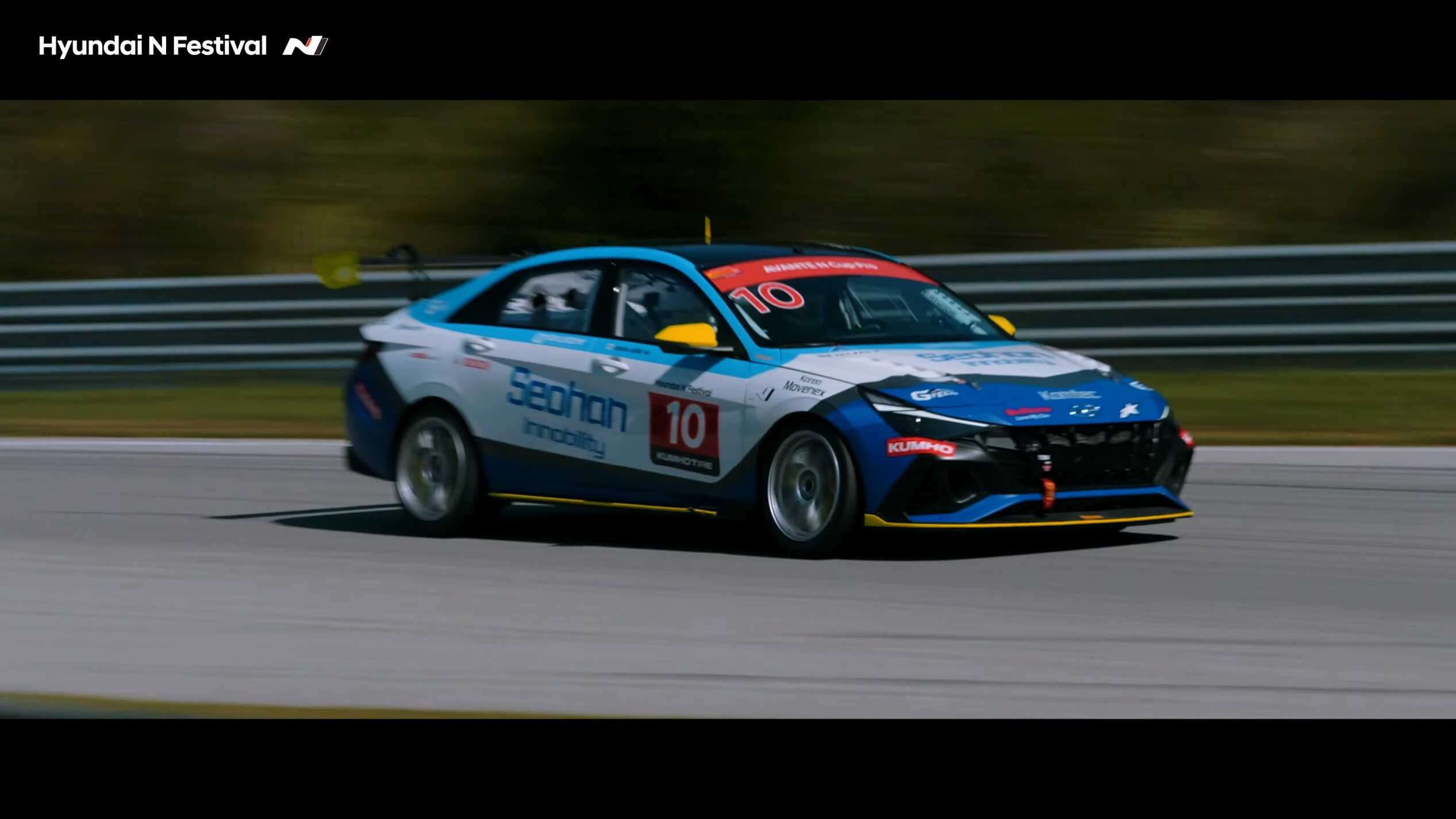 A blue-wrapped race car running on a circuit