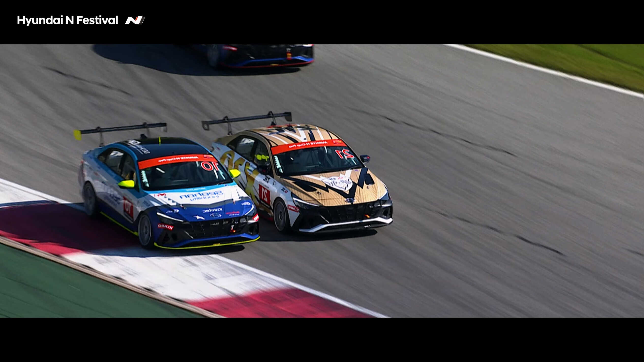 Two racing cars competing so close together that their wheels touch each other.
