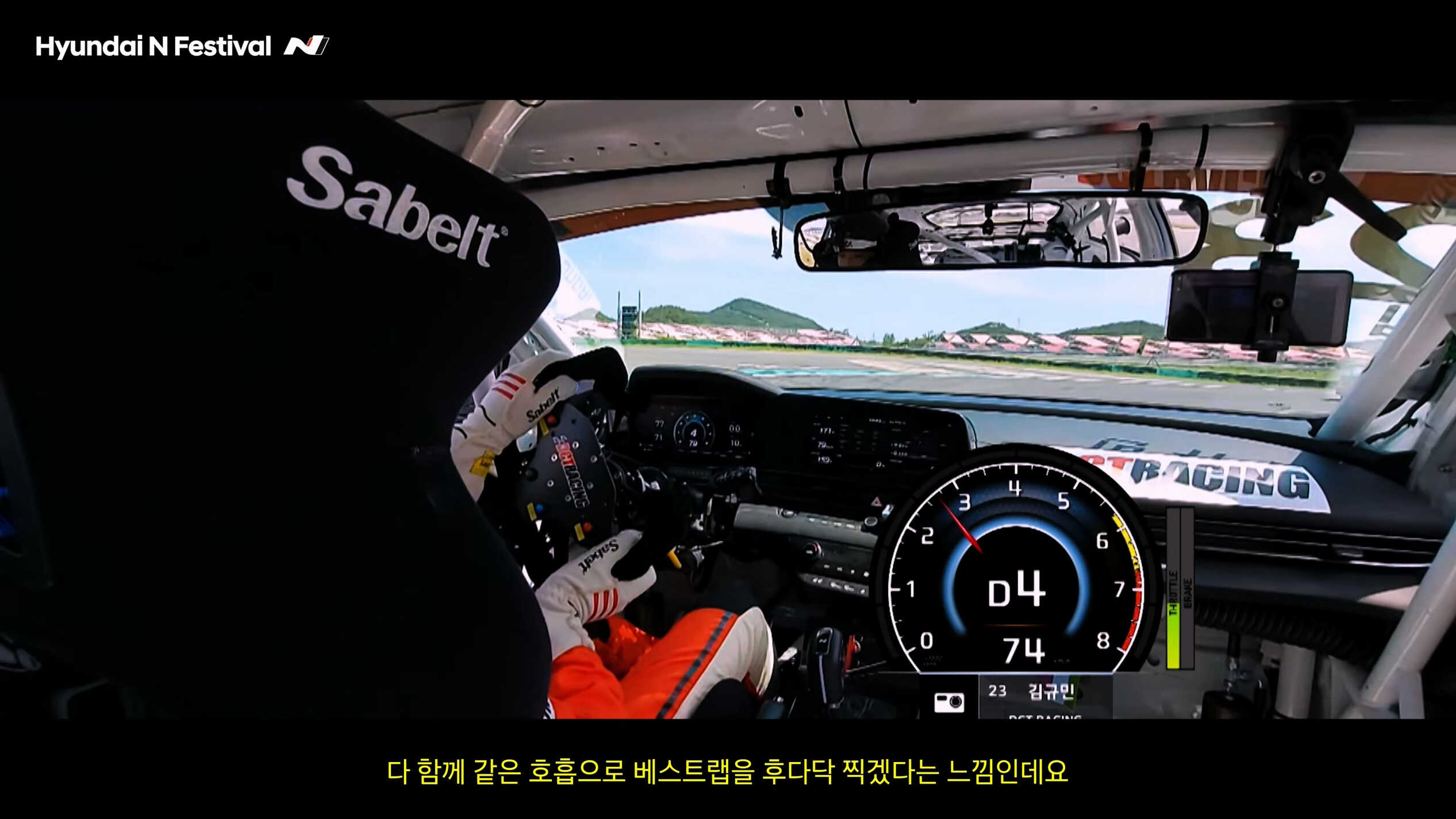 레이스 중인 차량의 실내 모습과 코너를 돌기 위해 스티어링을 돌리는 레이서의 모습