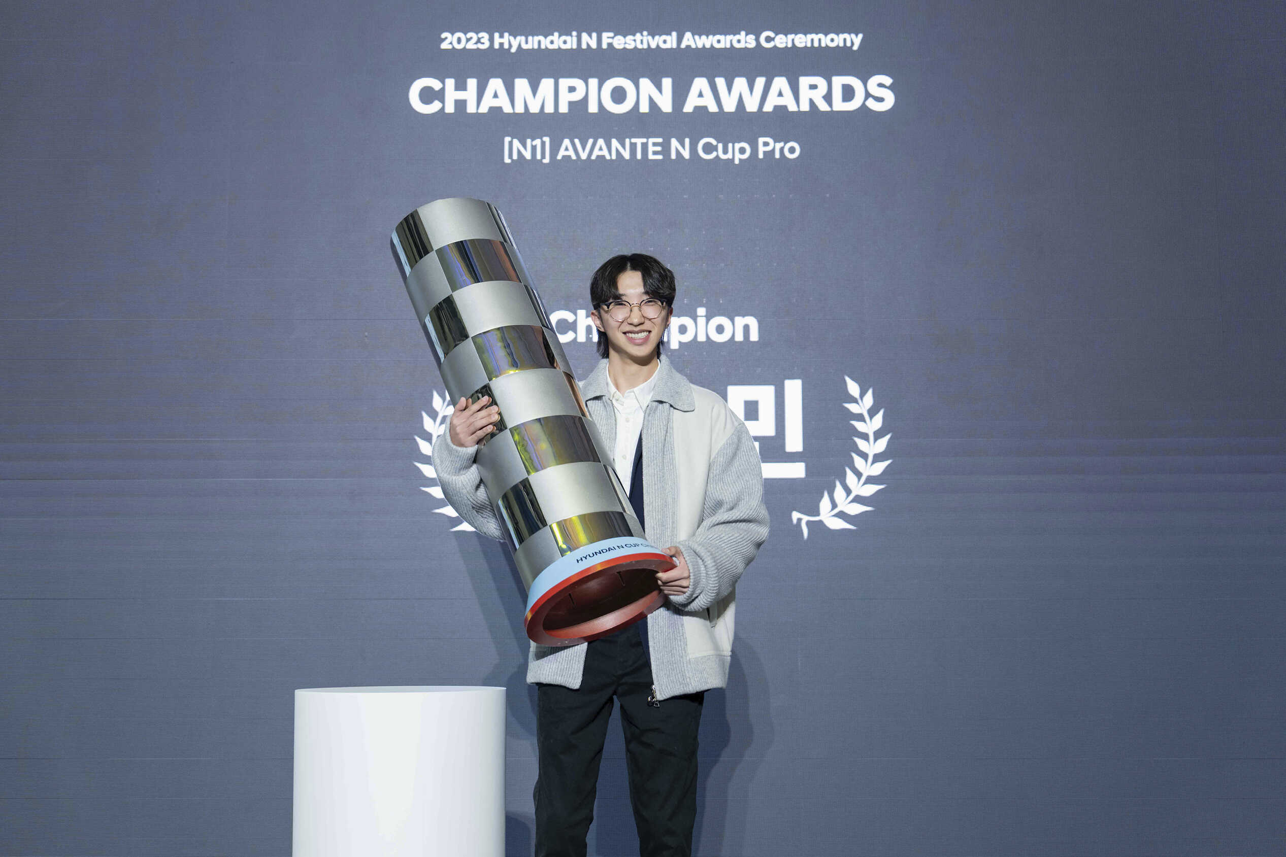 A driver holding the championship trophy