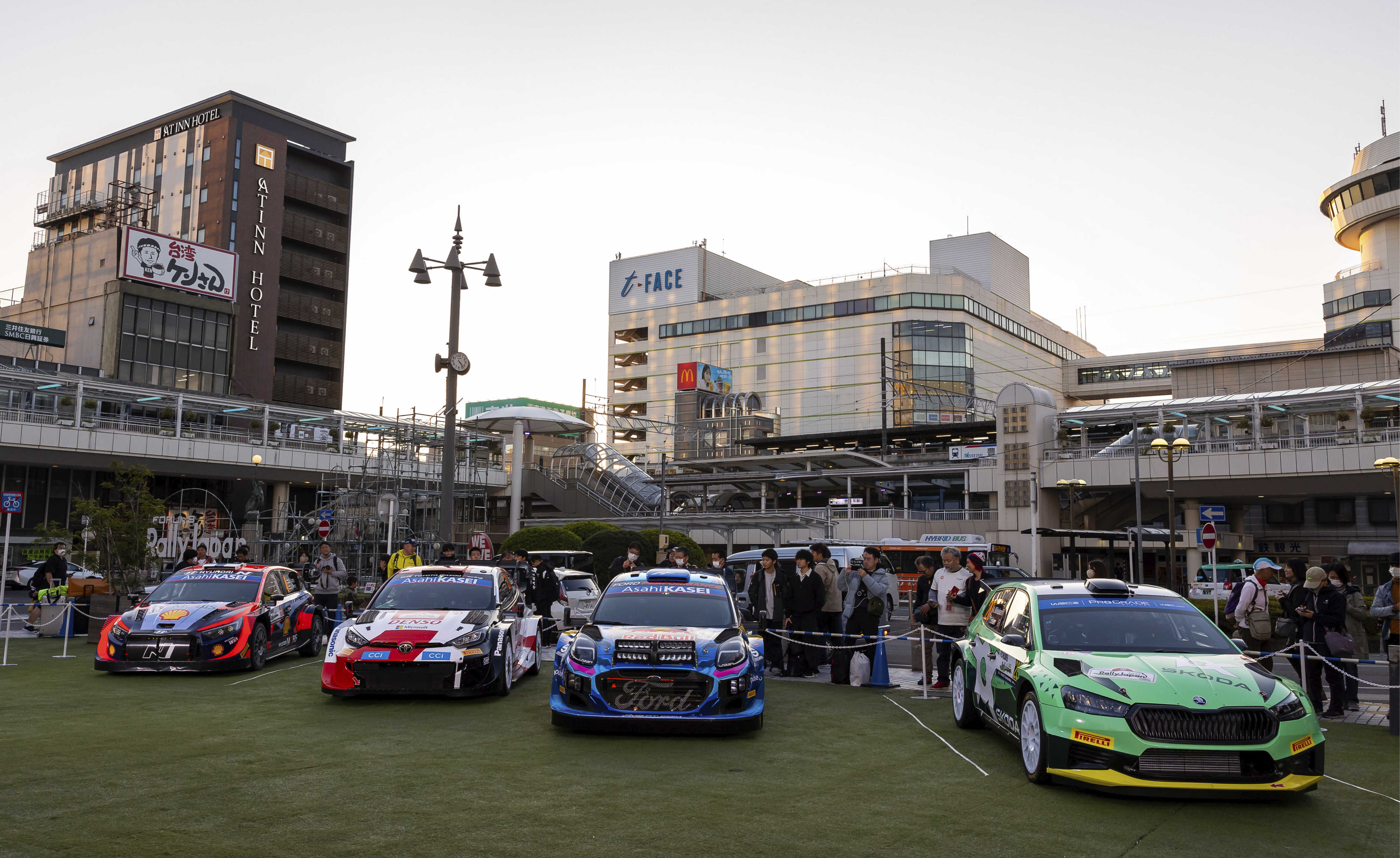 Front view of four WRC rally cars on display in a Japanese city