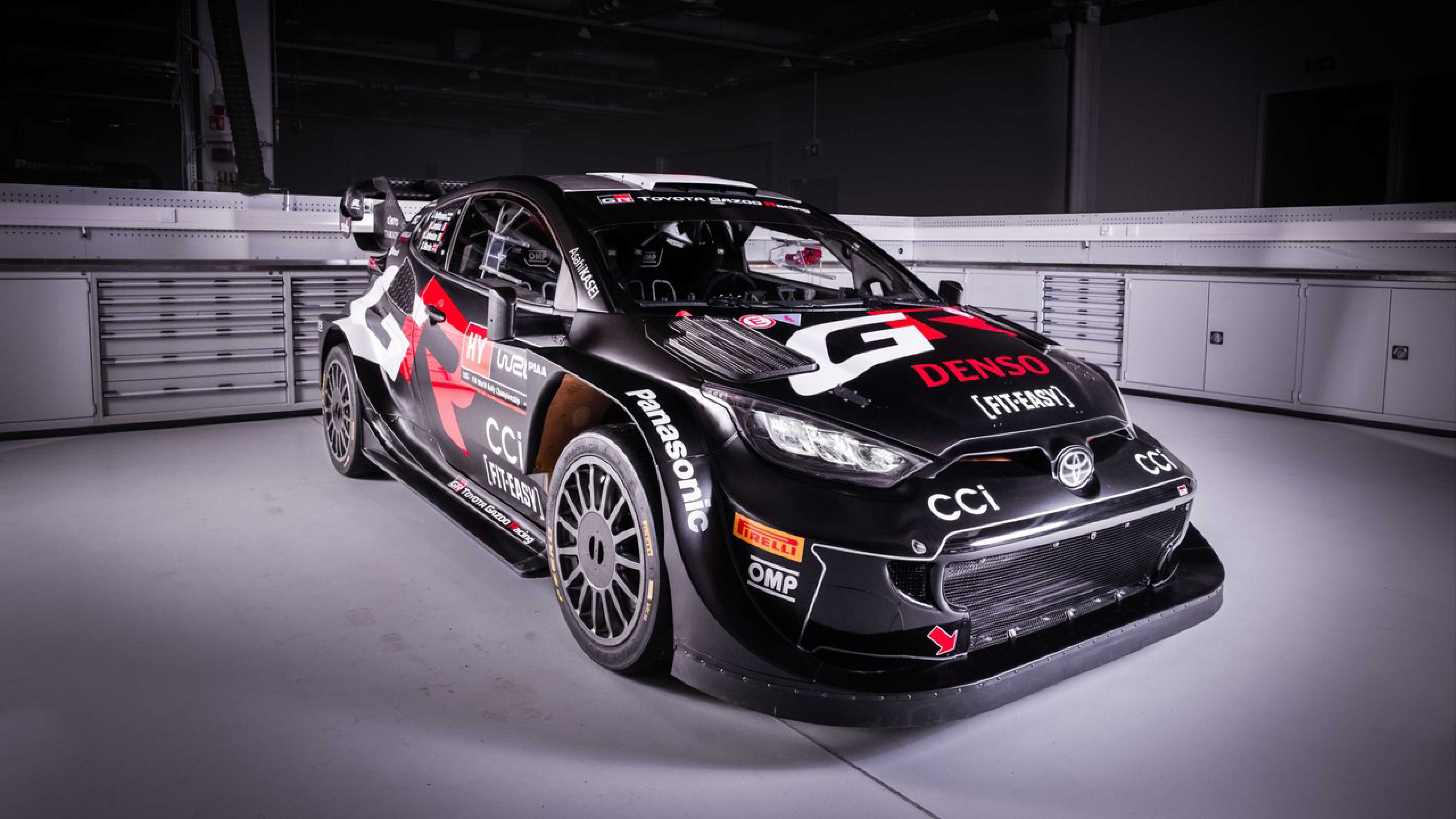 Front/side view of the Toyota team race car parked on a gray set.