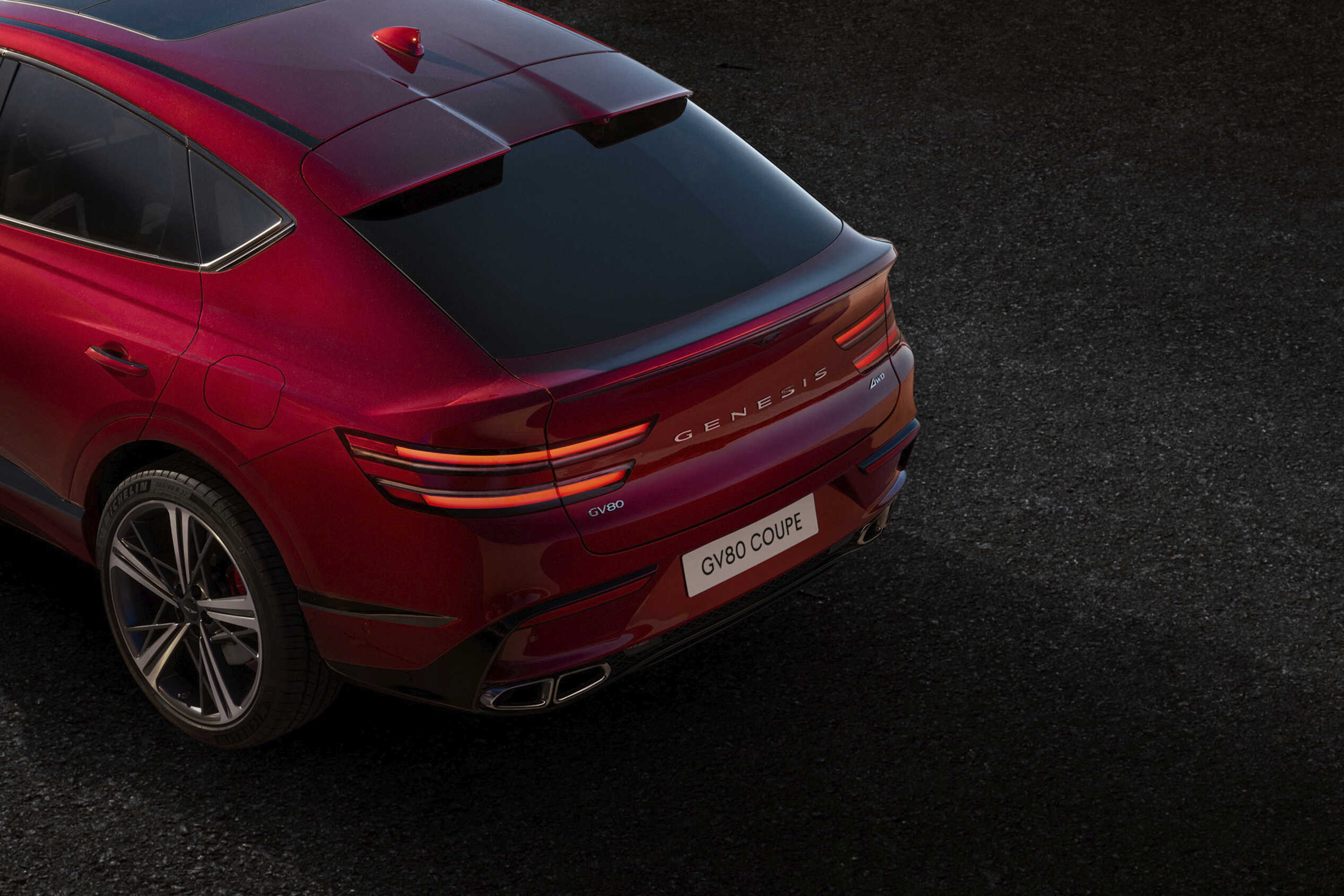 붉은 색의 제네시스 G80 쿠페를 후측의 위쪽에서 바라본 모습