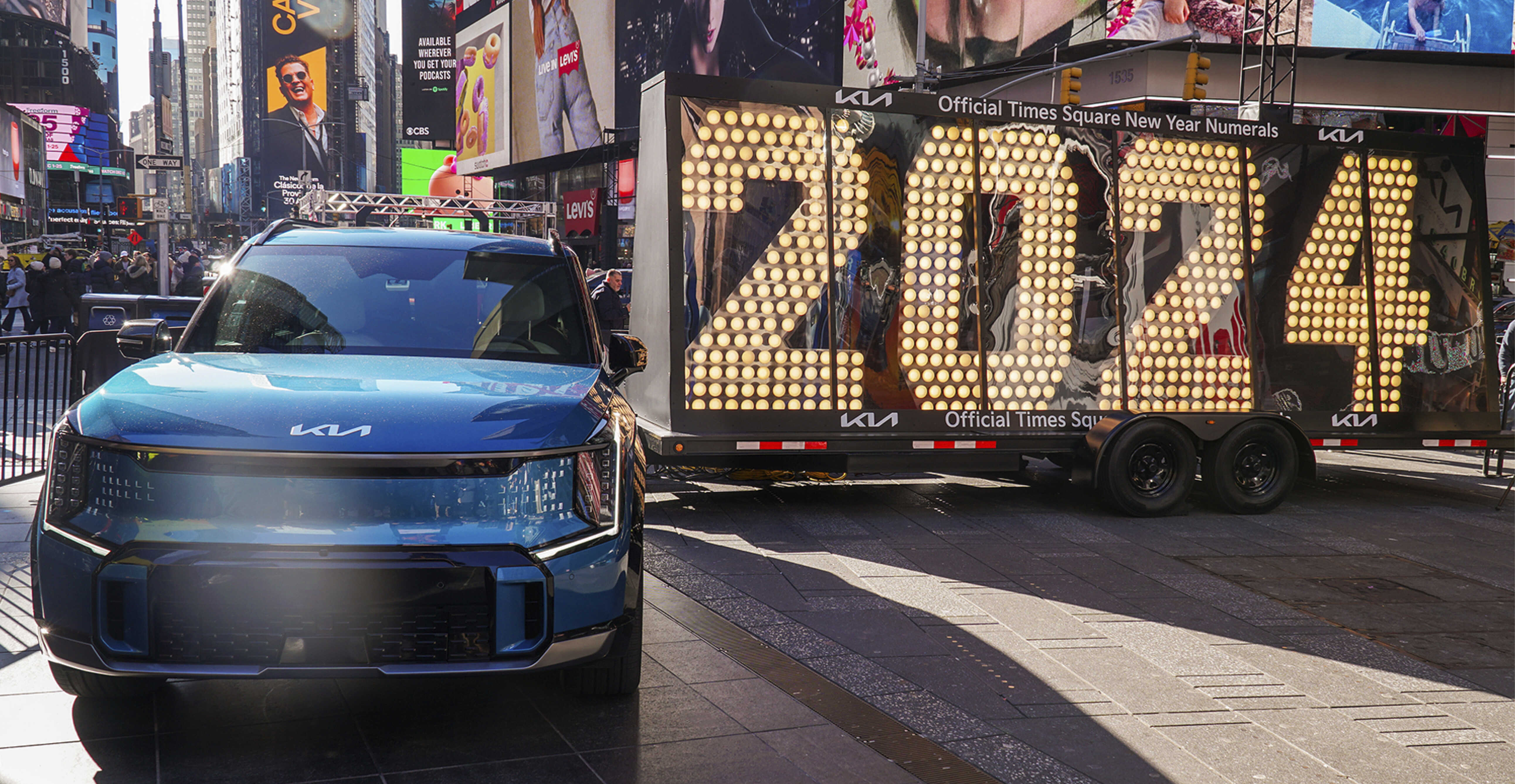 2024년을 알리는 전광판과 서 있는 기아 EV9의 모습